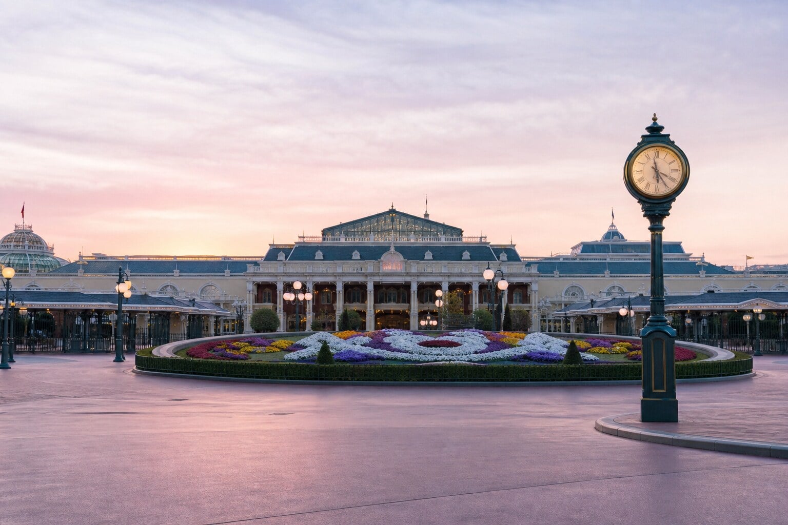 Tokyo Disneyland entrance in early morning light with minimal crowds and the park clock visible