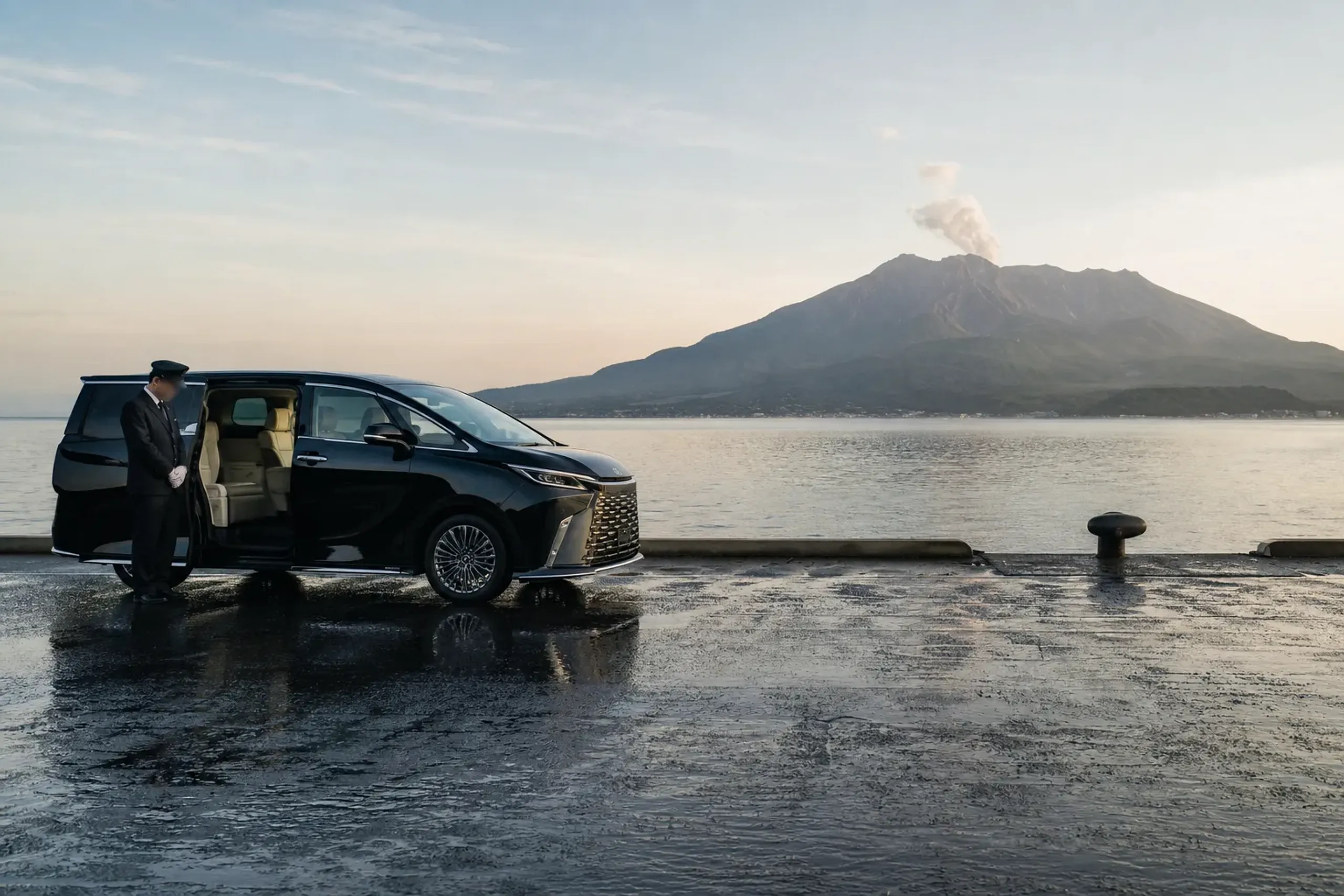Lexus LM 500 private chauffeur vehicle waiting at Kagoshima cruise port with Sakurajima behind