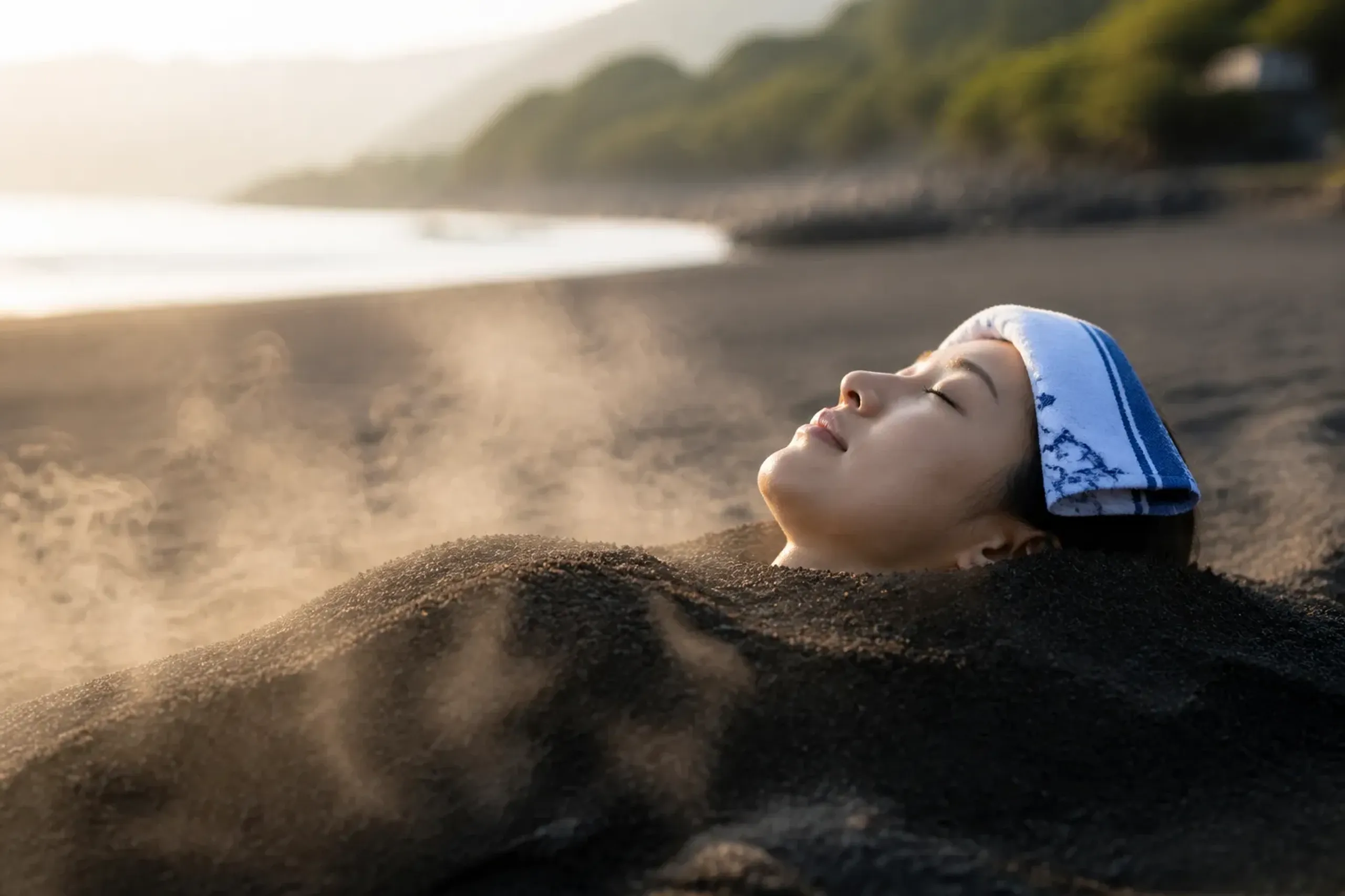 Guest buried in naturally heated volcanic sand at an Ibusuki beach onsen south of Kagoshima