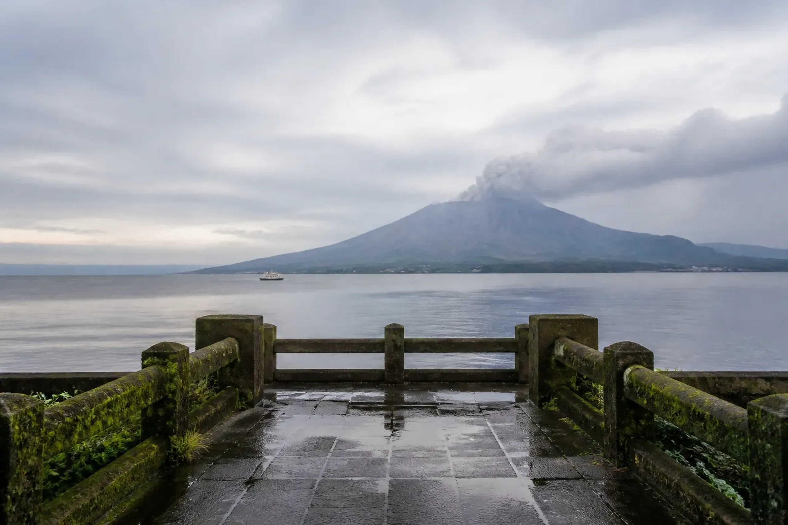 Sakurajima volcano puffing ash across Kinko Bay as seen from the Kagoshima waterfront at the southern tip of Kyushu