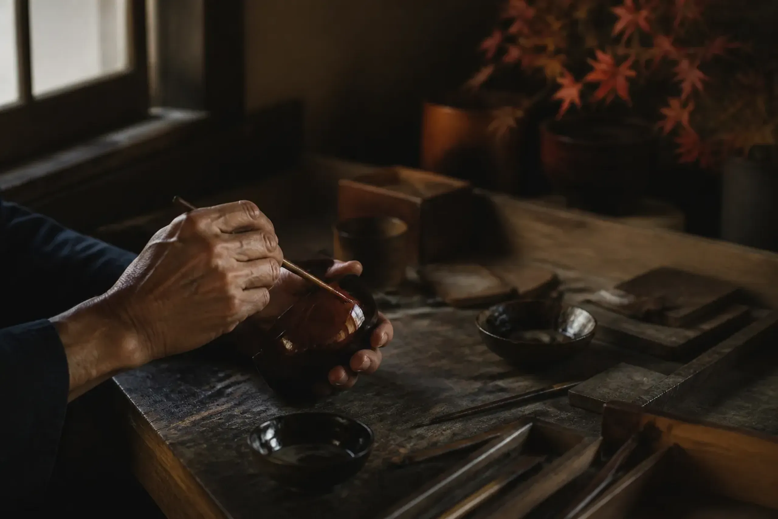 Hands of a Japanese artisan working with traditional tools at a private studio workbench
