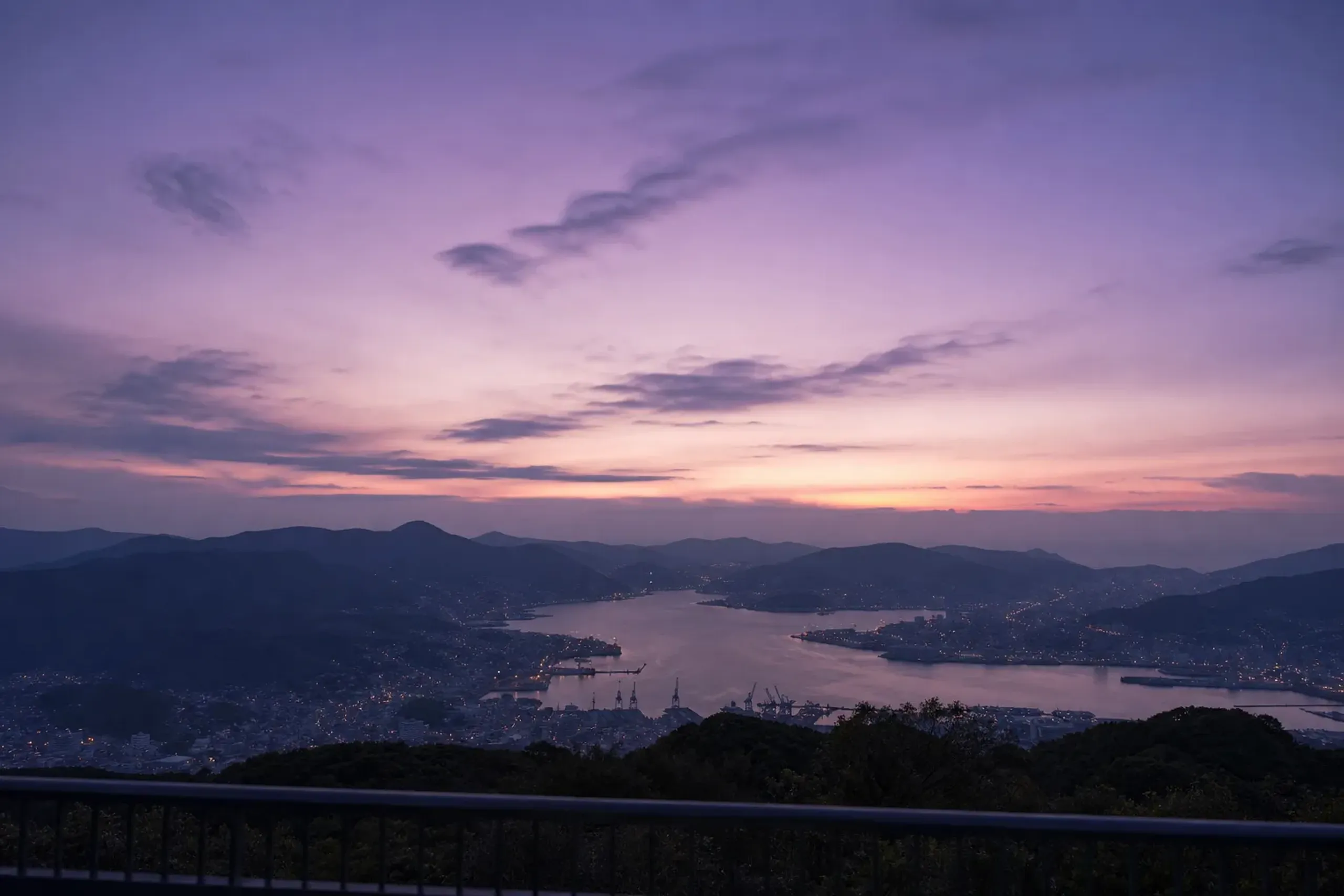 Dusk panorama of Nagasaki city lights and harbour from Mount Inasa summit