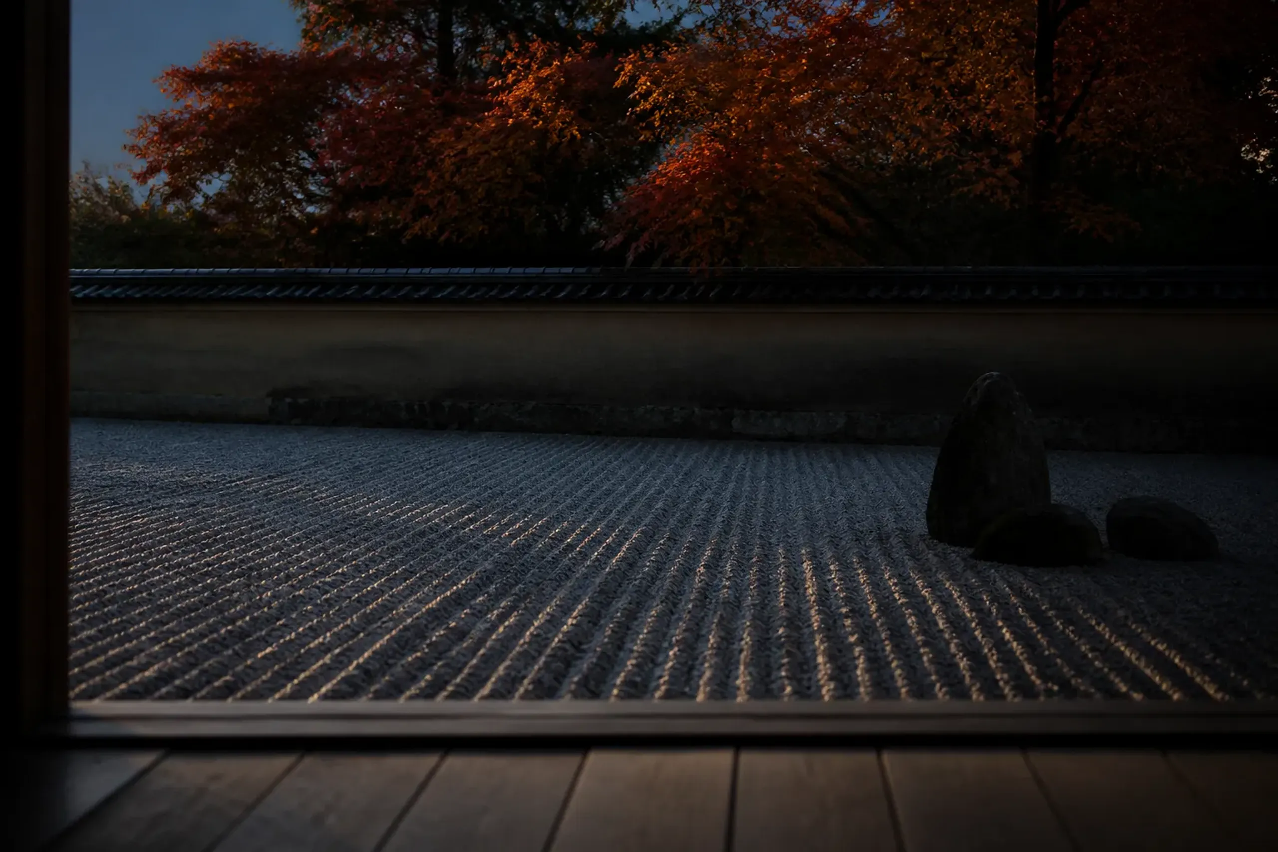 A quiet zen rock garden in Kyoto fading into the evening shadows