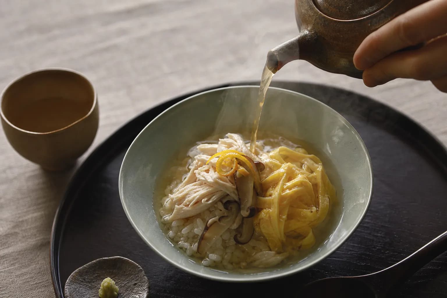 Refined plating of Amami keihan chicken rice with clear broth poured at the table