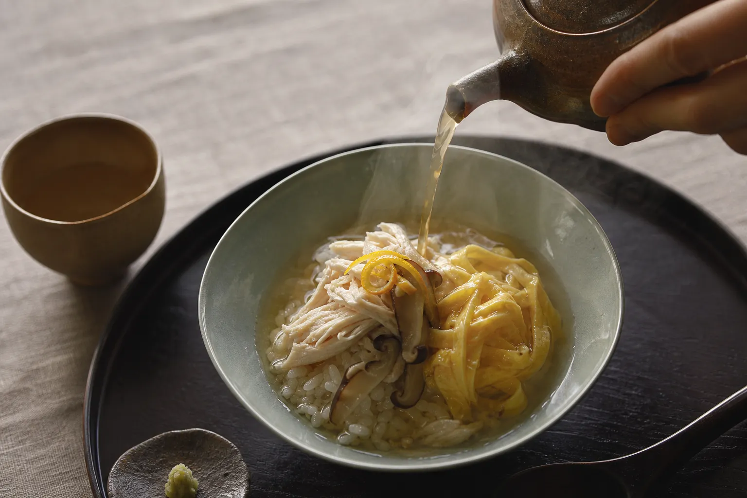 Refined plating of Amami keihan chicken rice with clear broth poured at the table