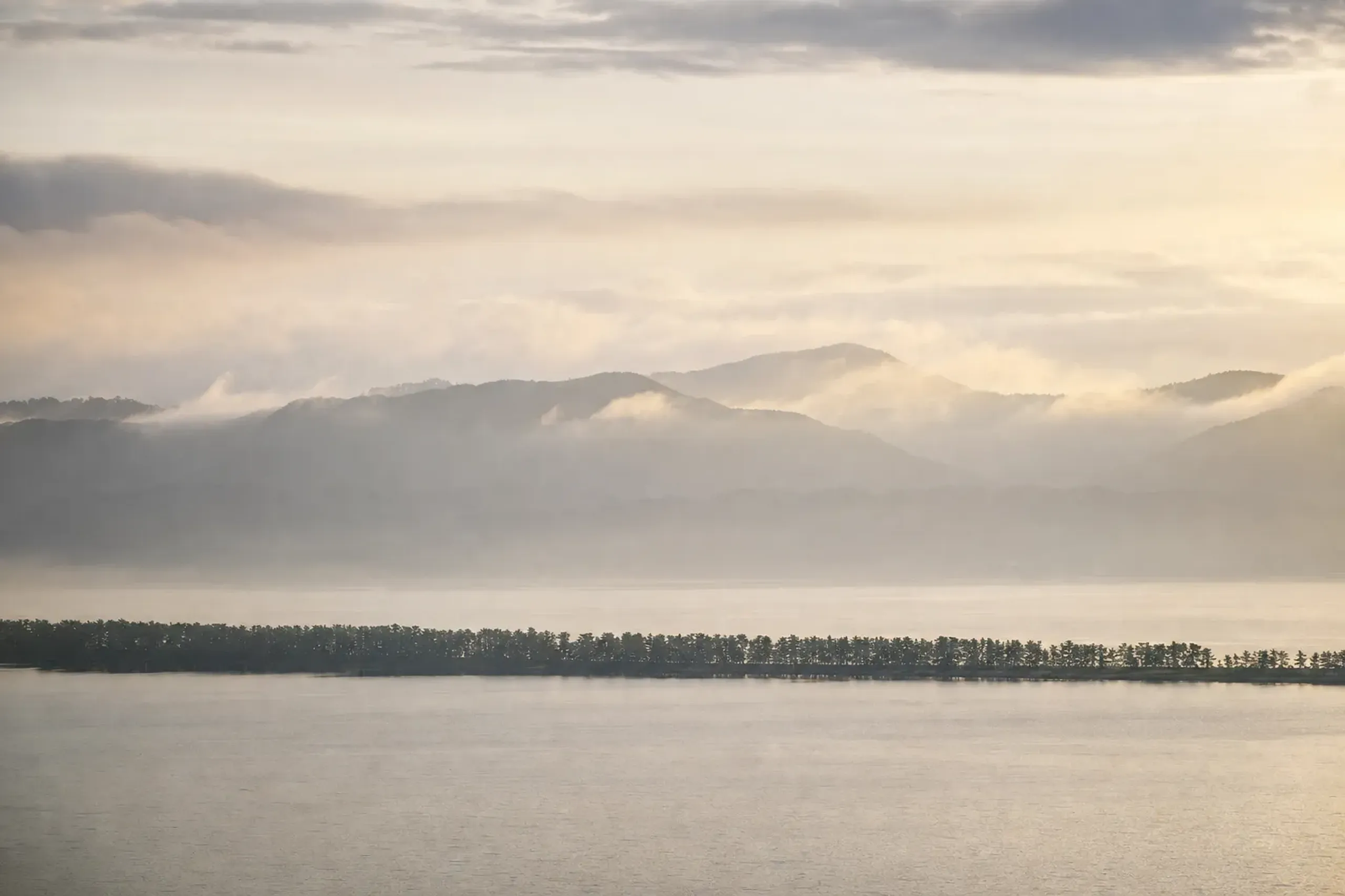 The 3.3-kilometre pine-tree-lined Amanohashidate sandbar stretching across Miyazu Bay, its roughly 7,000 gnarled pines forming a green path over the water