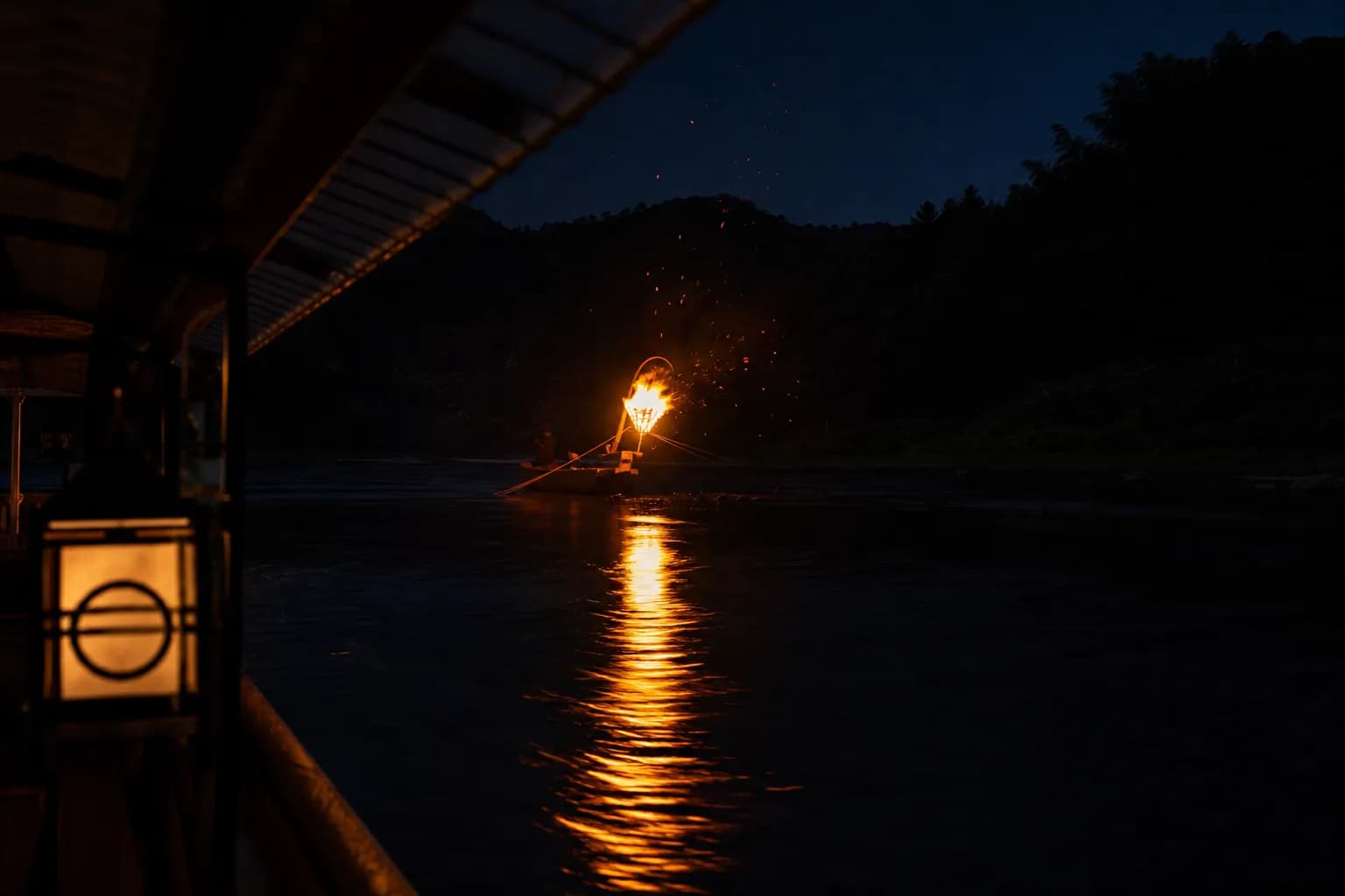 Traditional ukai cormorant fishing boats with torch flames on the Nagara River in Gifu City at night