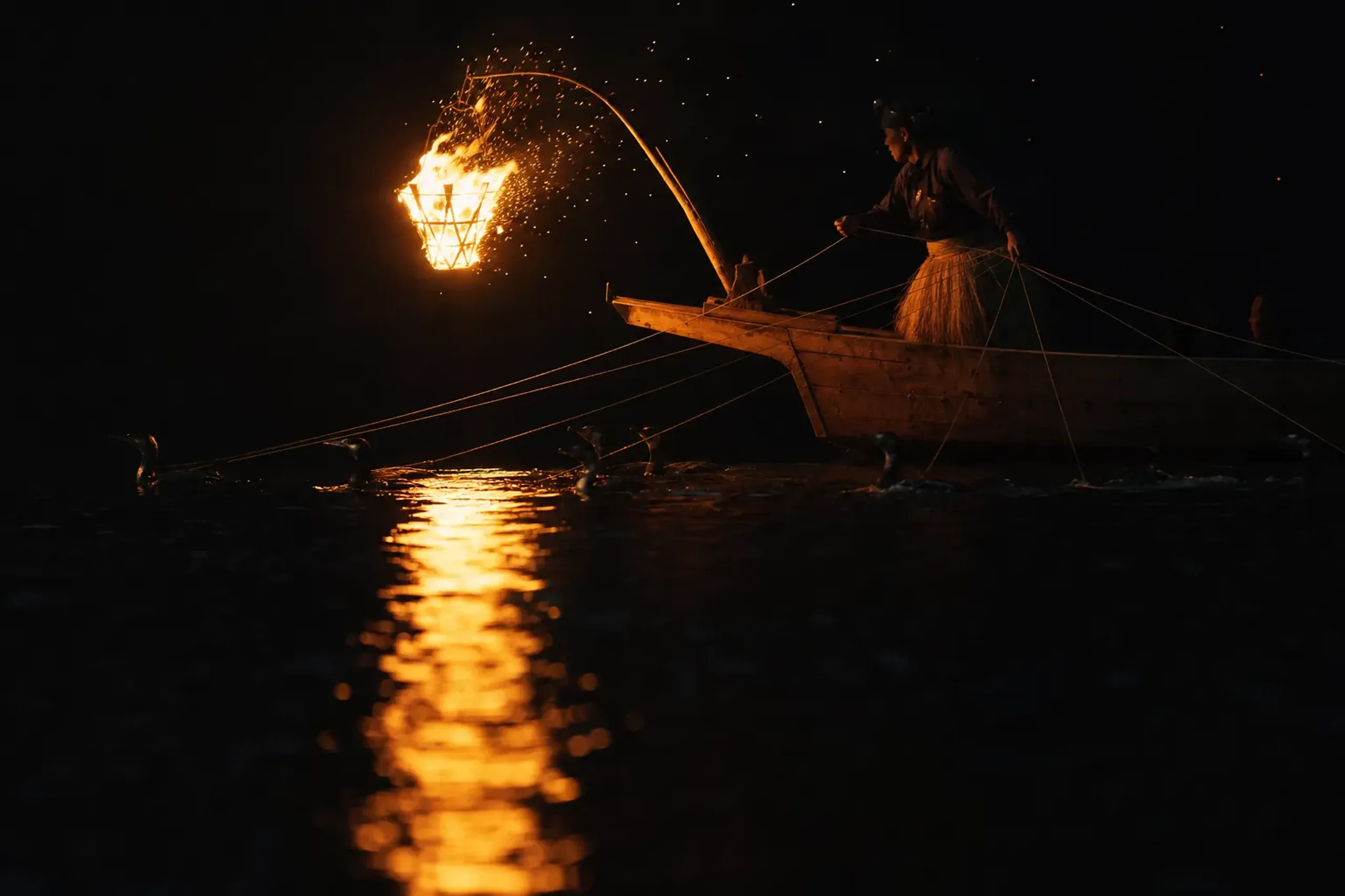Traditional ukai cormorant fishing boats with torch flames on the Nagara River in Gifu City at night