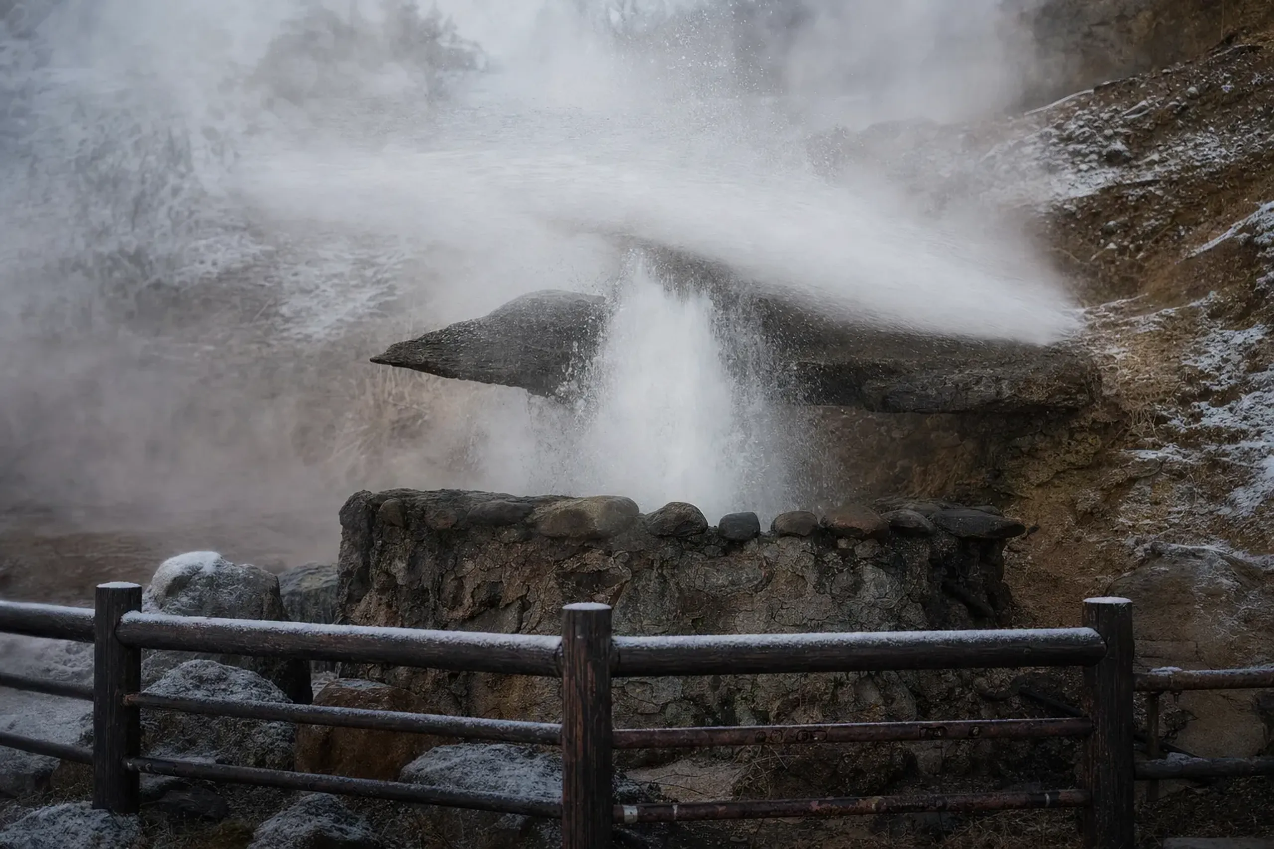 The natural geyser of Tatsumaki Jigoku (Waterspout Hell) erupting a high-pressure jet of steam through the sightseeing circuit railings in Kannawa