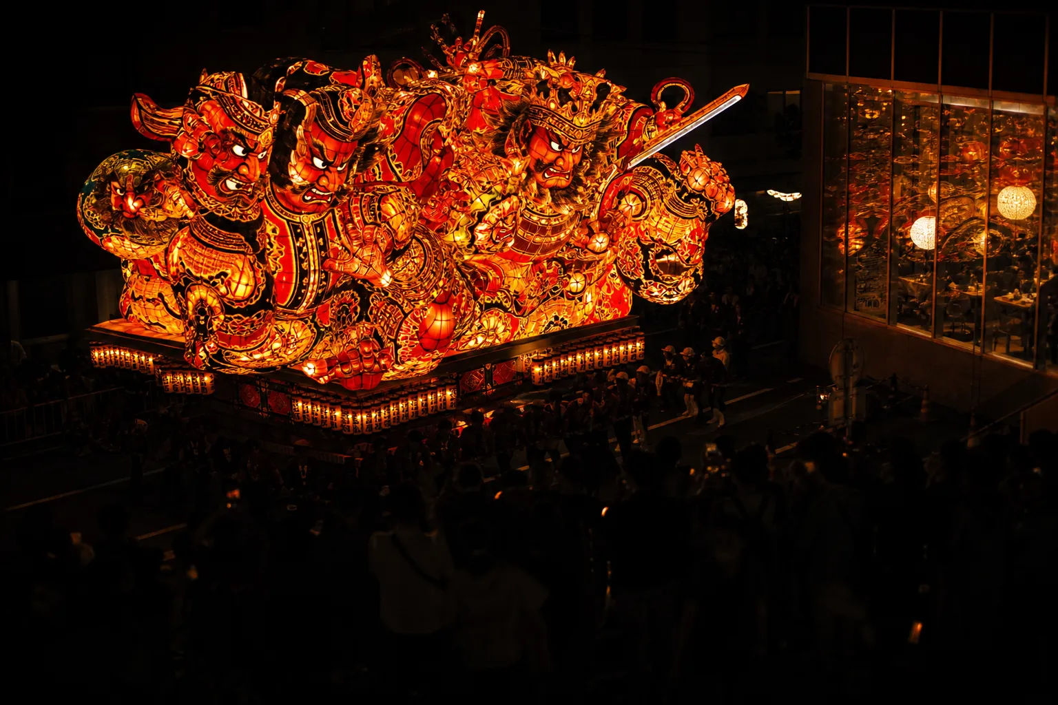 Illuminated Nebuta float during Aomori Nebuta Matsuri at night with crowds watching