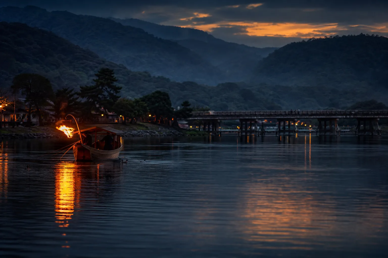 Cormorant fishing boat with fire on the Oi River at Arashiyama Kyoto at dusk