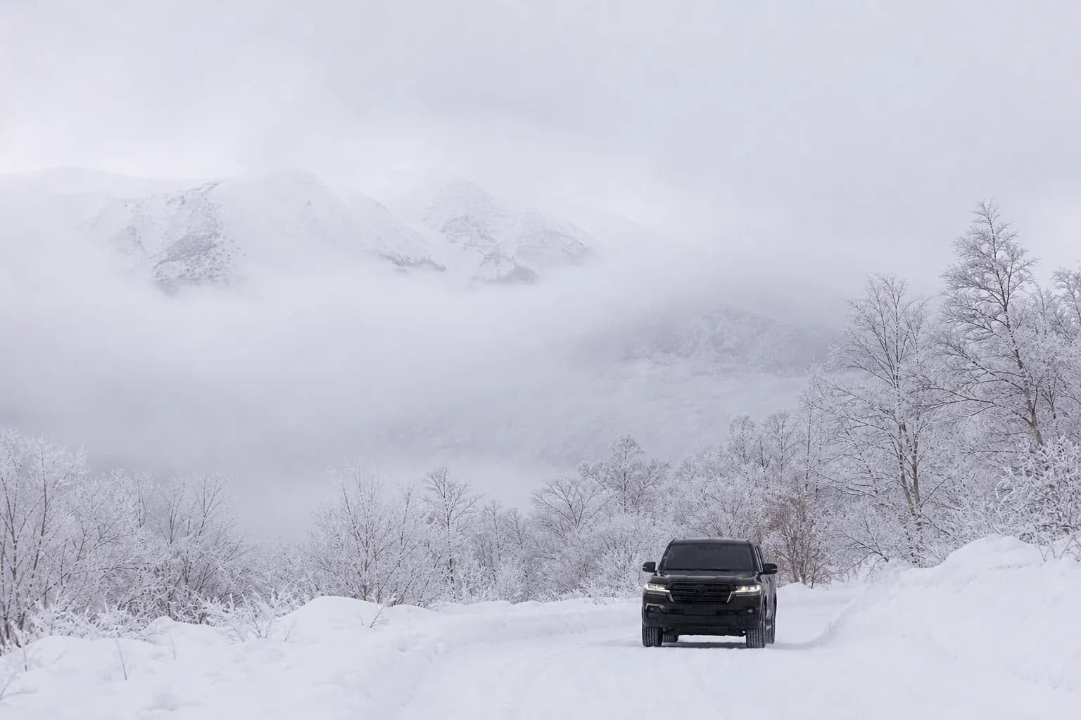 Luxury 4WD transport vehicle on a snowy road in Daisetsuzan National Park.