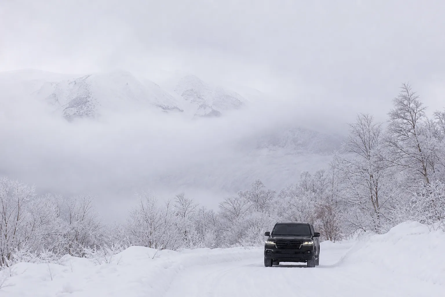 Luxury 4WD transport vehicle on a snowy road in Daisetsuzan National Park.