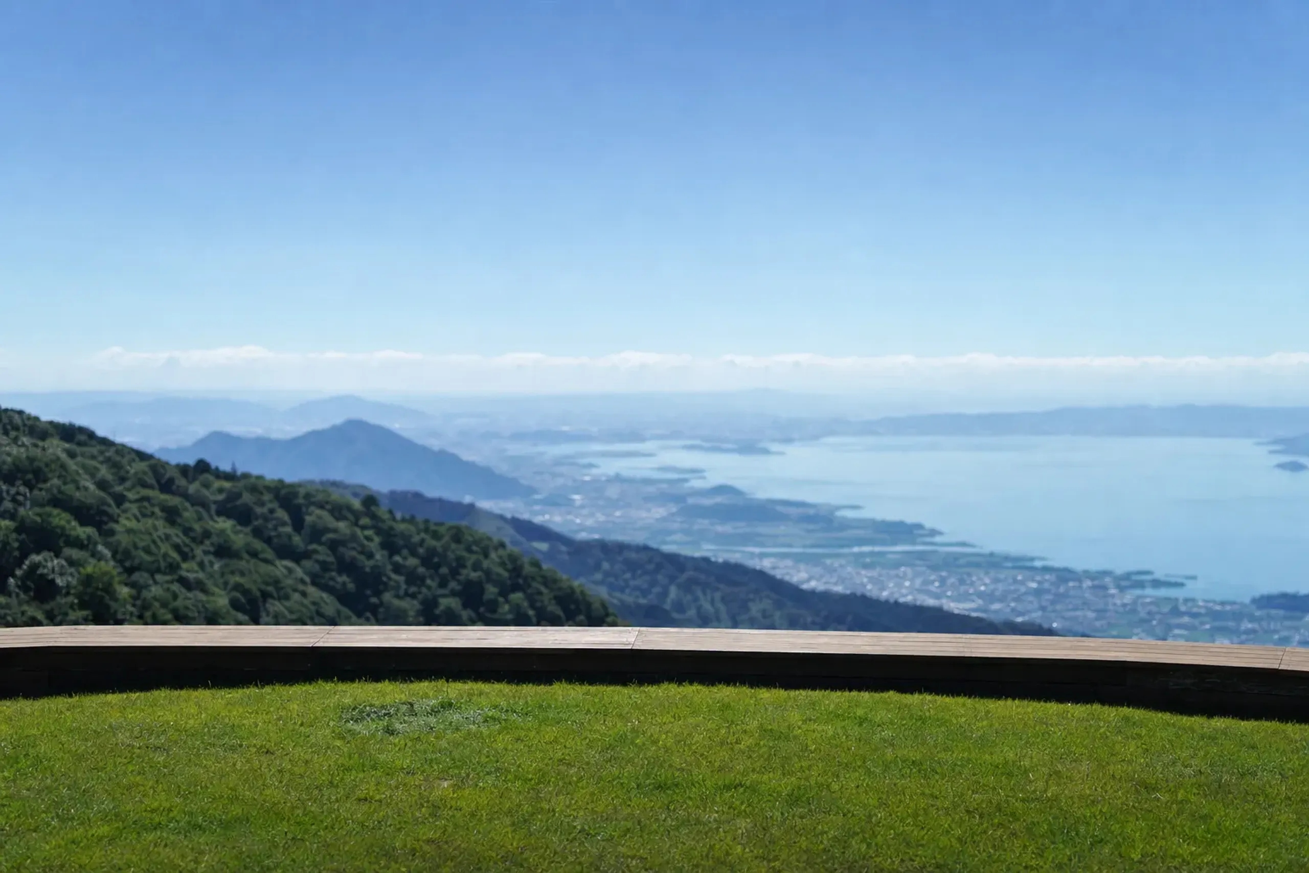 the wide green expanse of Mount Hōrai's summit terrain at Café 360 (1,174m) overlooking Lake Biwa under clear summer skies