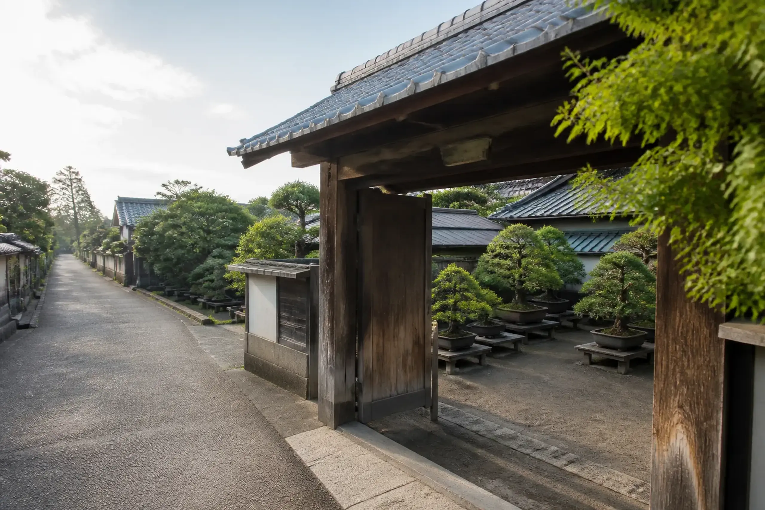 Traditional wooden gate opening into a bonsai nursery in Omiya Bonsai Village, Saitama.