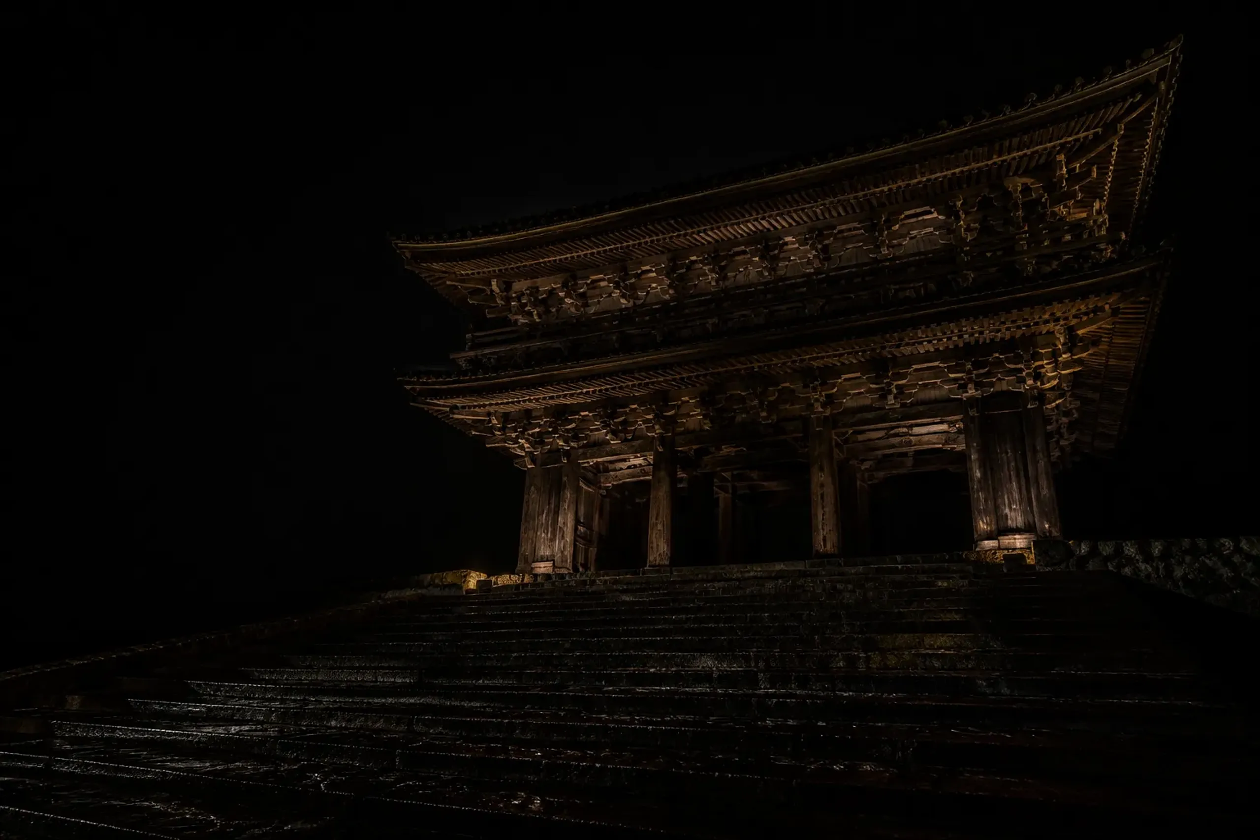 Chion-in Sanmon gate in Kyoto at night with low lighting and deep shadows