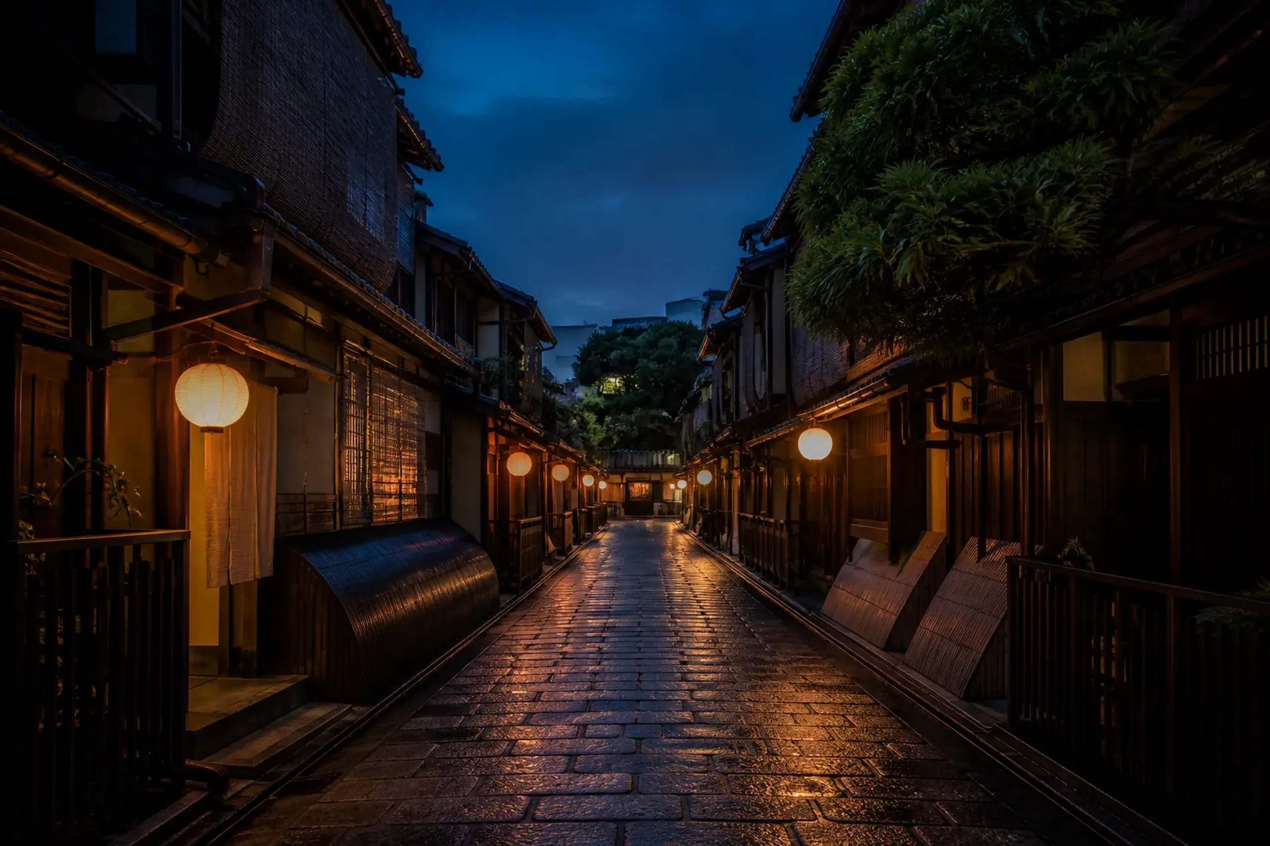 Empty traditional wooden lane in Gion Kyoto at dusk with glowing lanterns and no people