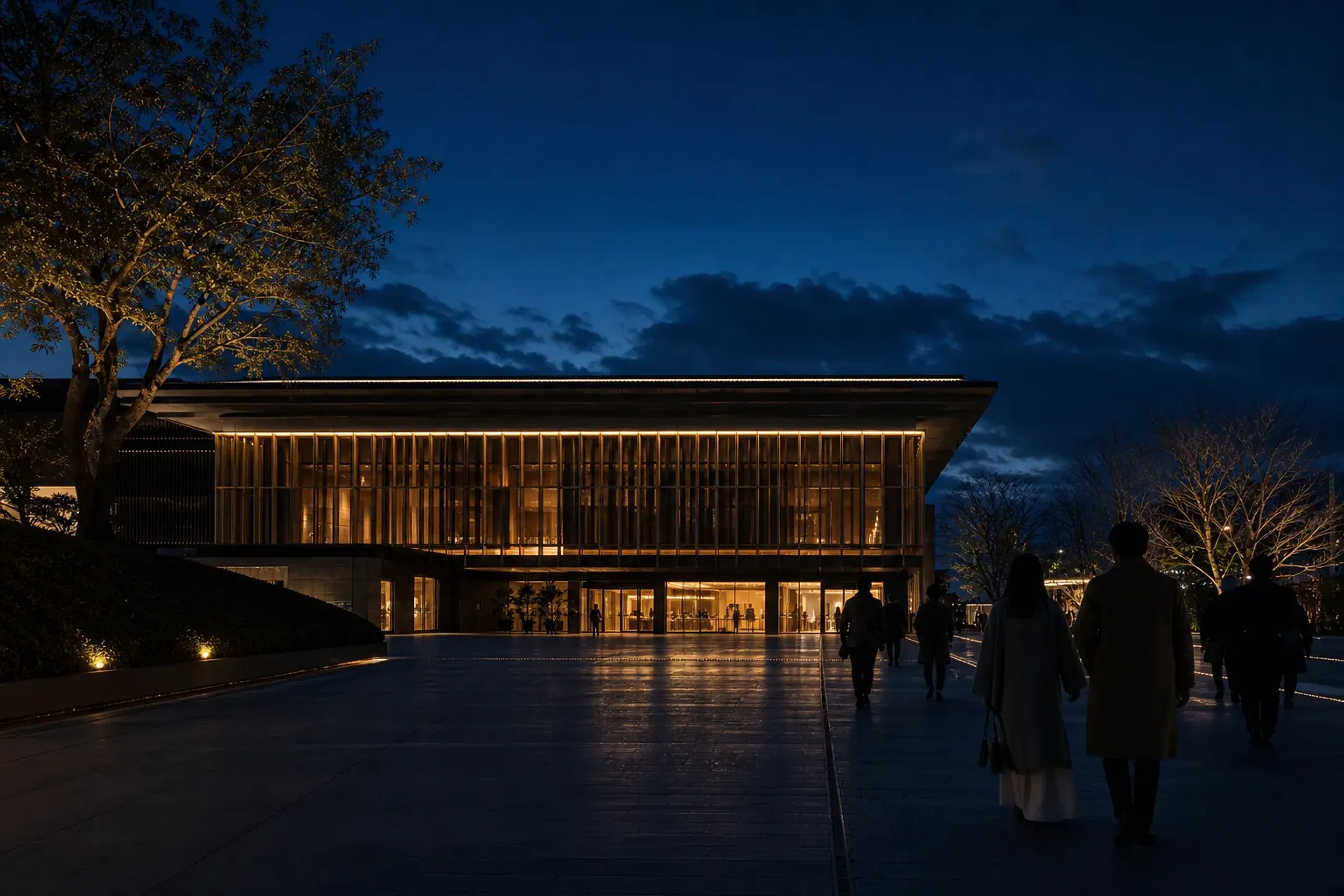 ROHM Theatre Kyoto exterior at night with lights on and guests arriving for a performance