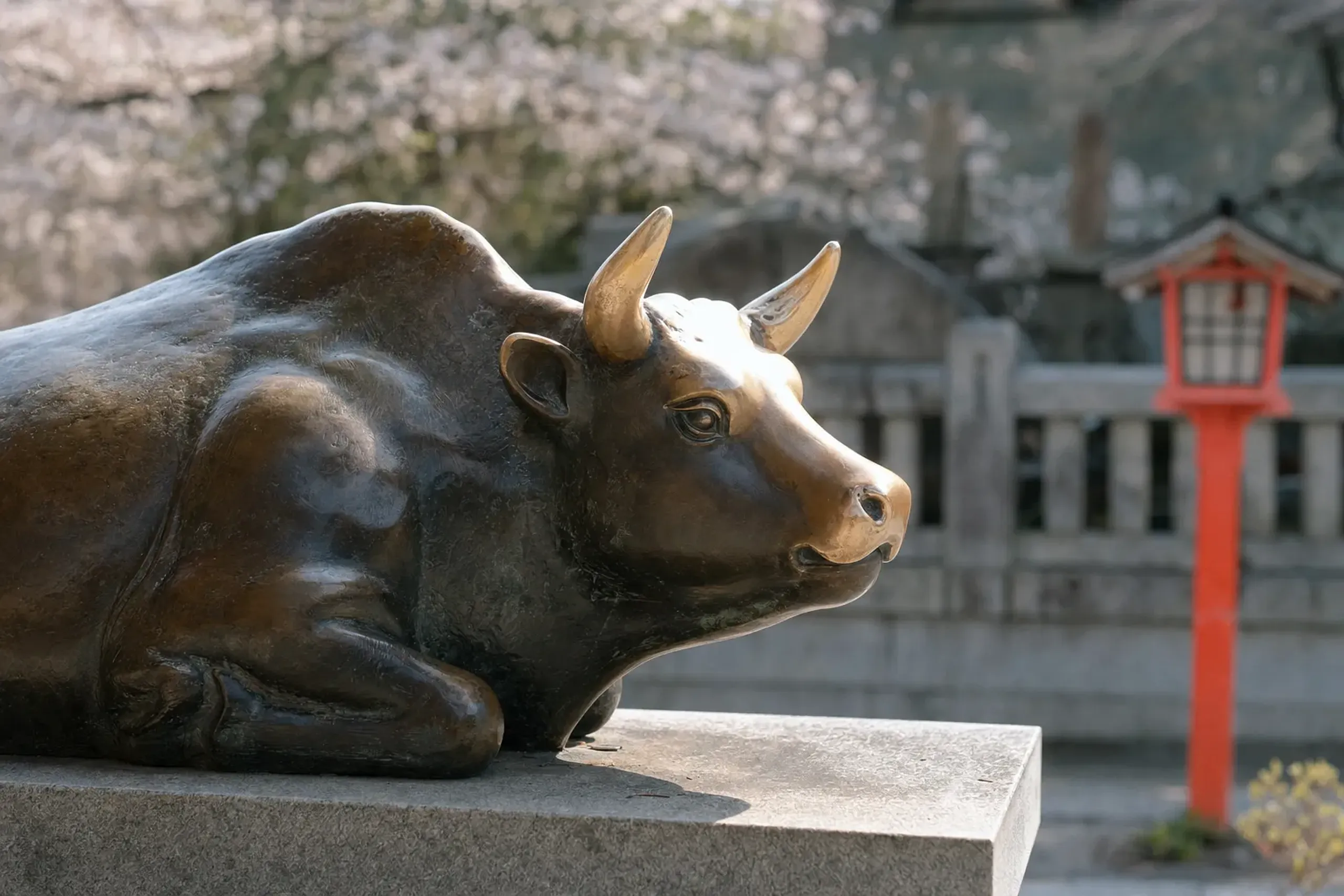 the bronze reclining ox statue at Dazaifu Tenmangū, its head and horns worn smooth from centuries of visitors' hands