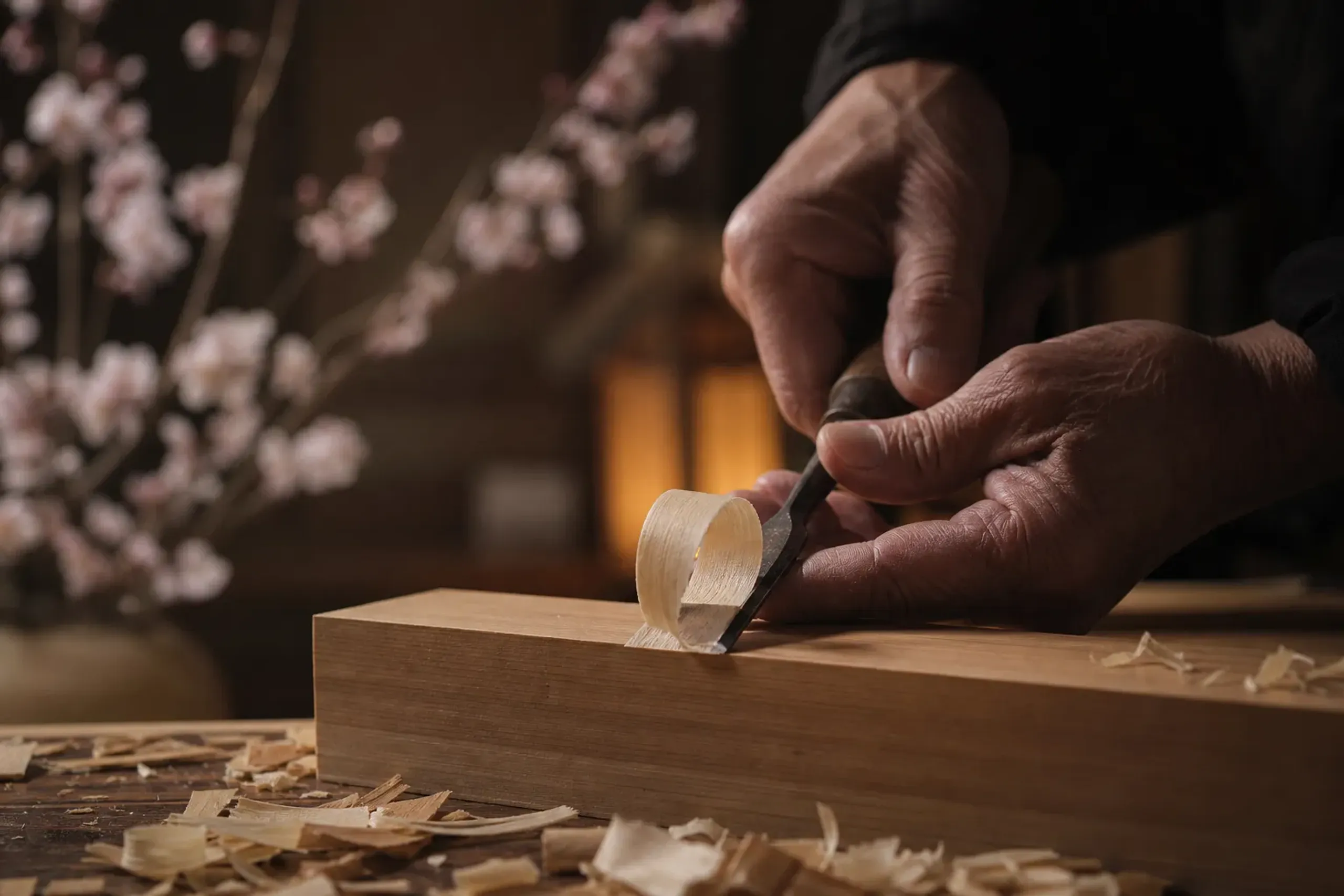 Hands of a Japanese artisan working with a fine tool in a workshop