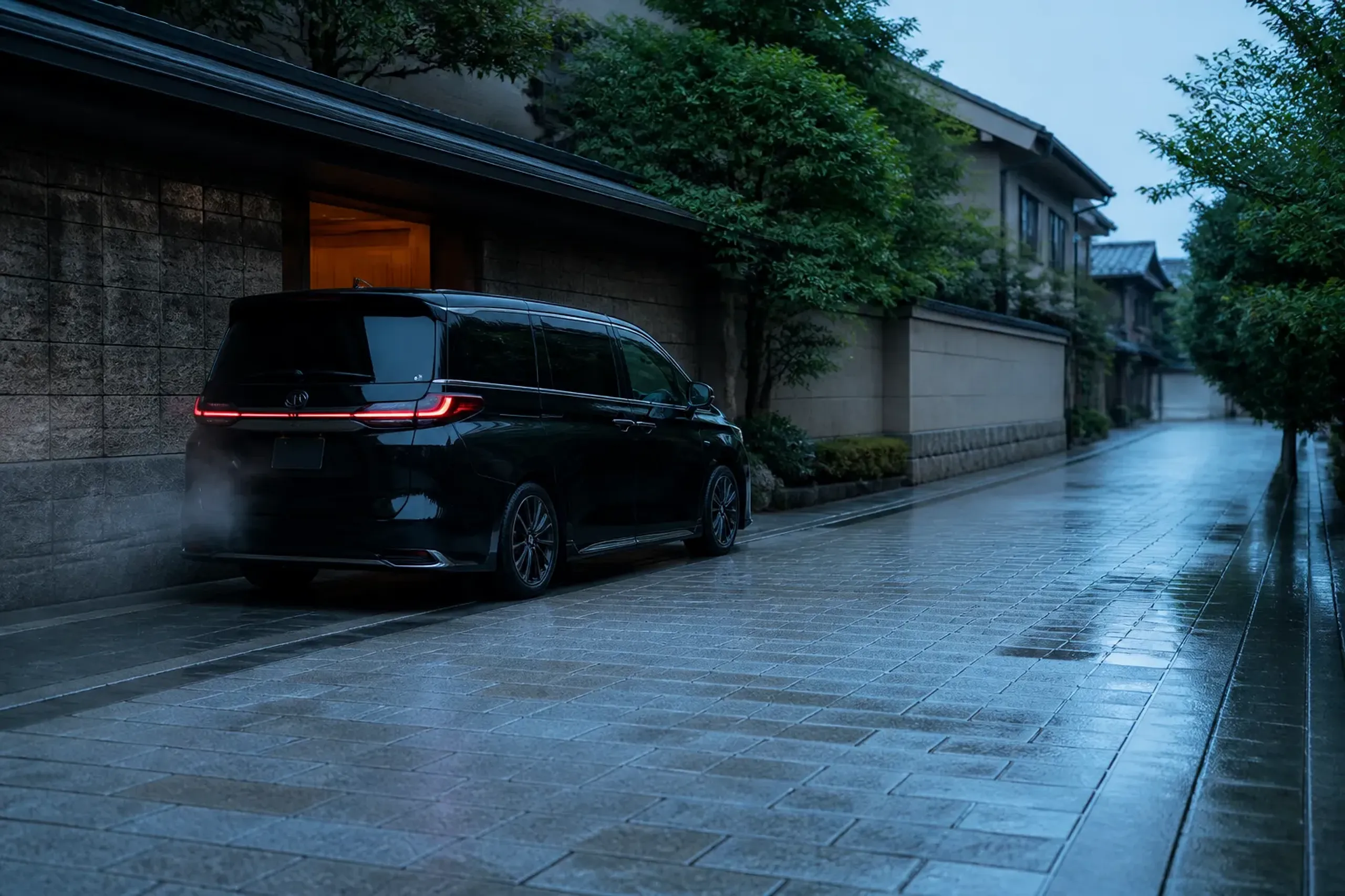 a single black chauffeured Lexus LM 500 idling at a discreet side entrance of a Kyoto hotel at dawn, its screened rear cabin darkened, empty pavement stretching ahead in soft early light