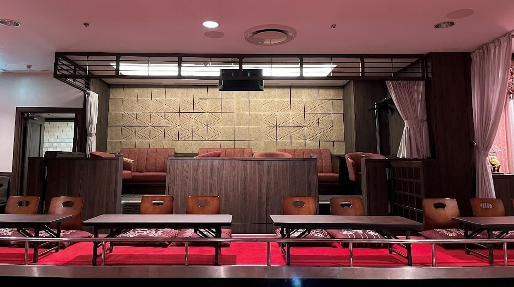 A luxurious premium seat with a counter and masu-style seats overlooking an arena.