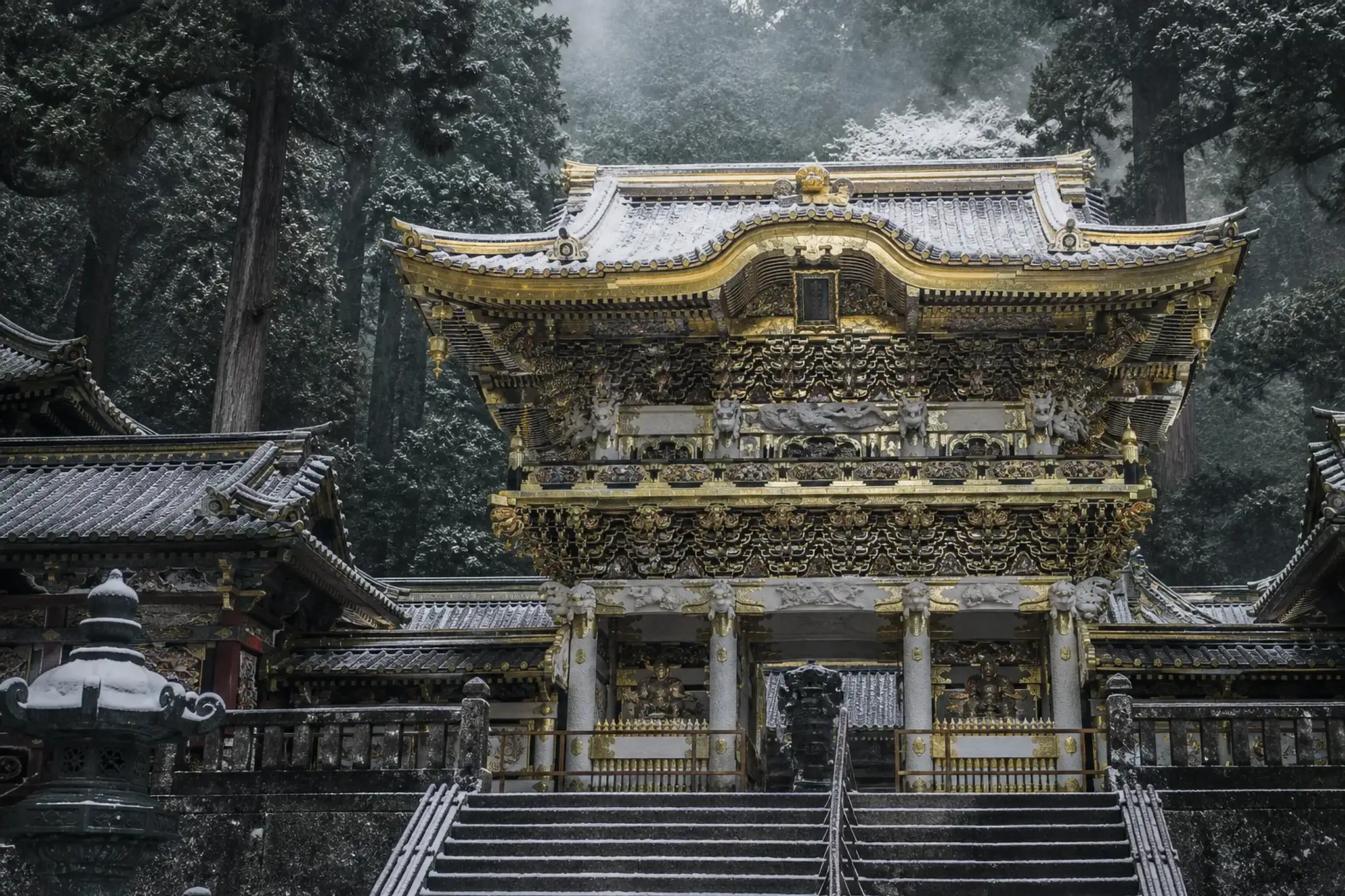 the ornate carved and gilded Yomeimon Gate of Toshogu Shrine in the forested mountains of Nikko