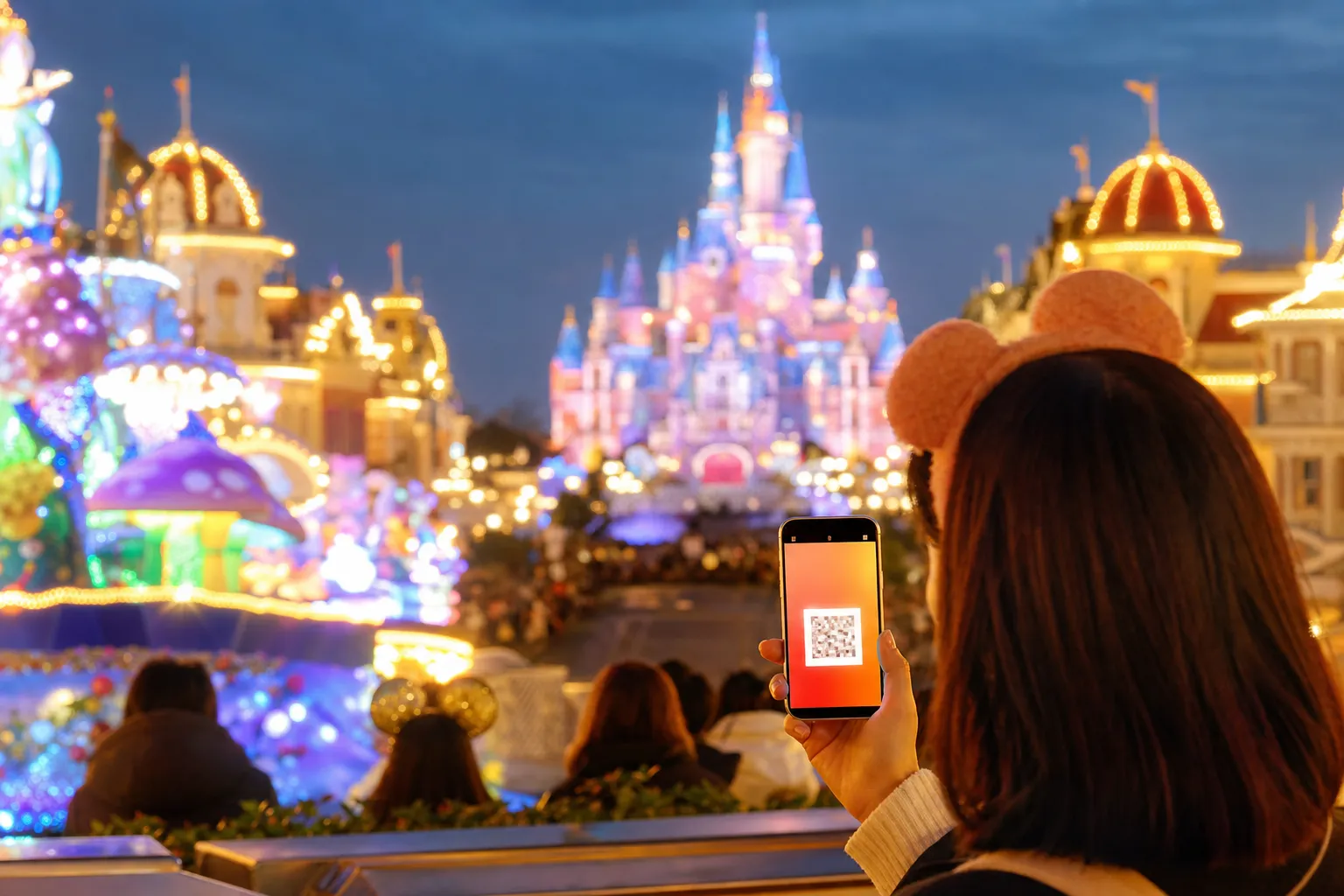 A guest opening the official Tokyo Disney Resort app on a phone at the park entrance