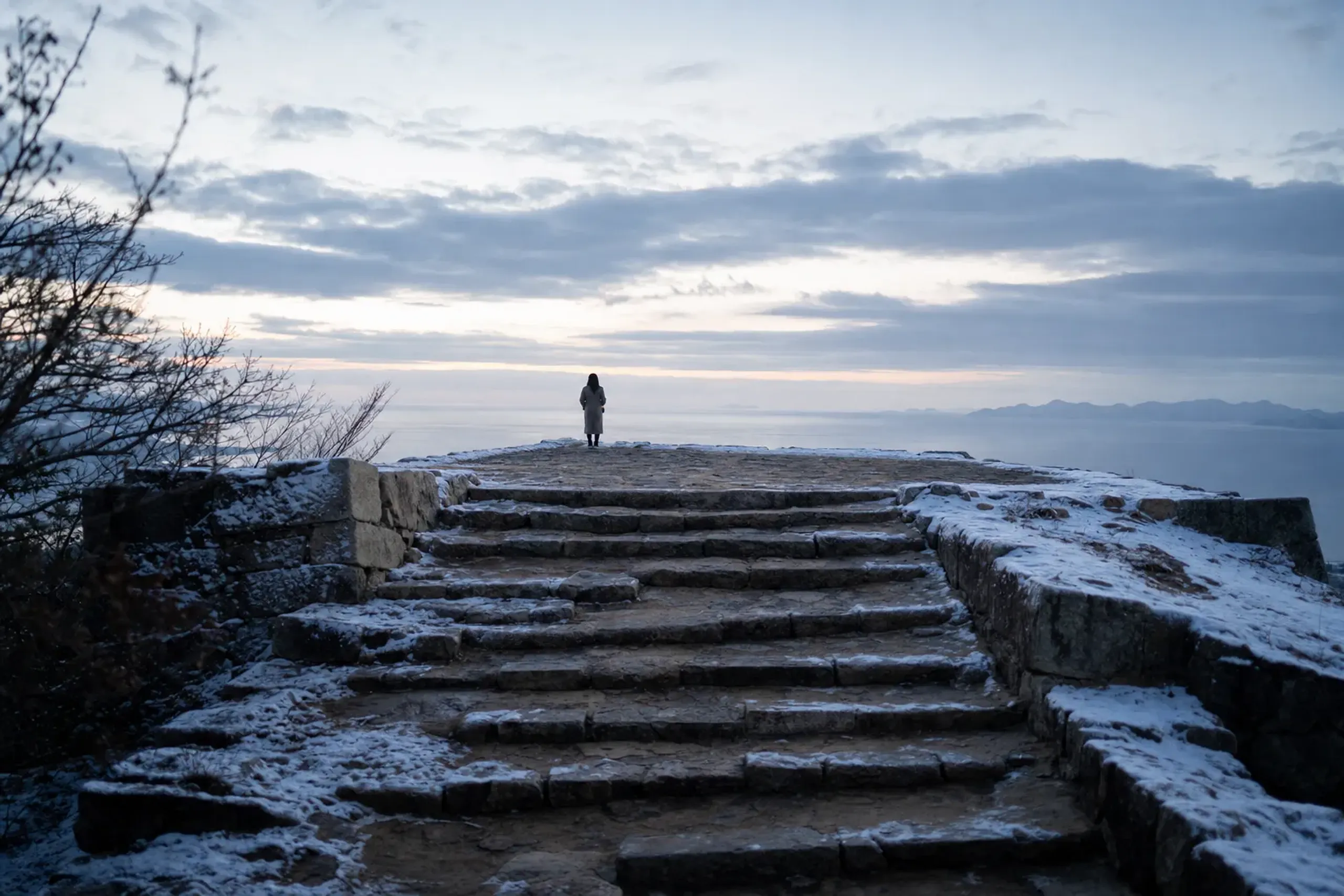 the stone steps and approach leading up to the tenshudai keep base of Fukuoka Castle, with the sea-facing view running clear to the horizon from the summit