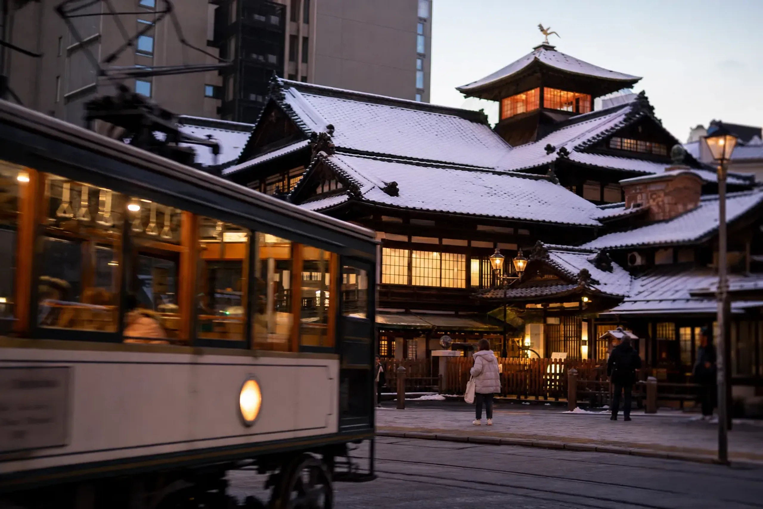 Historic Dōgo Onsen bathhouse set within the working city of Matsuyama with a passing tram