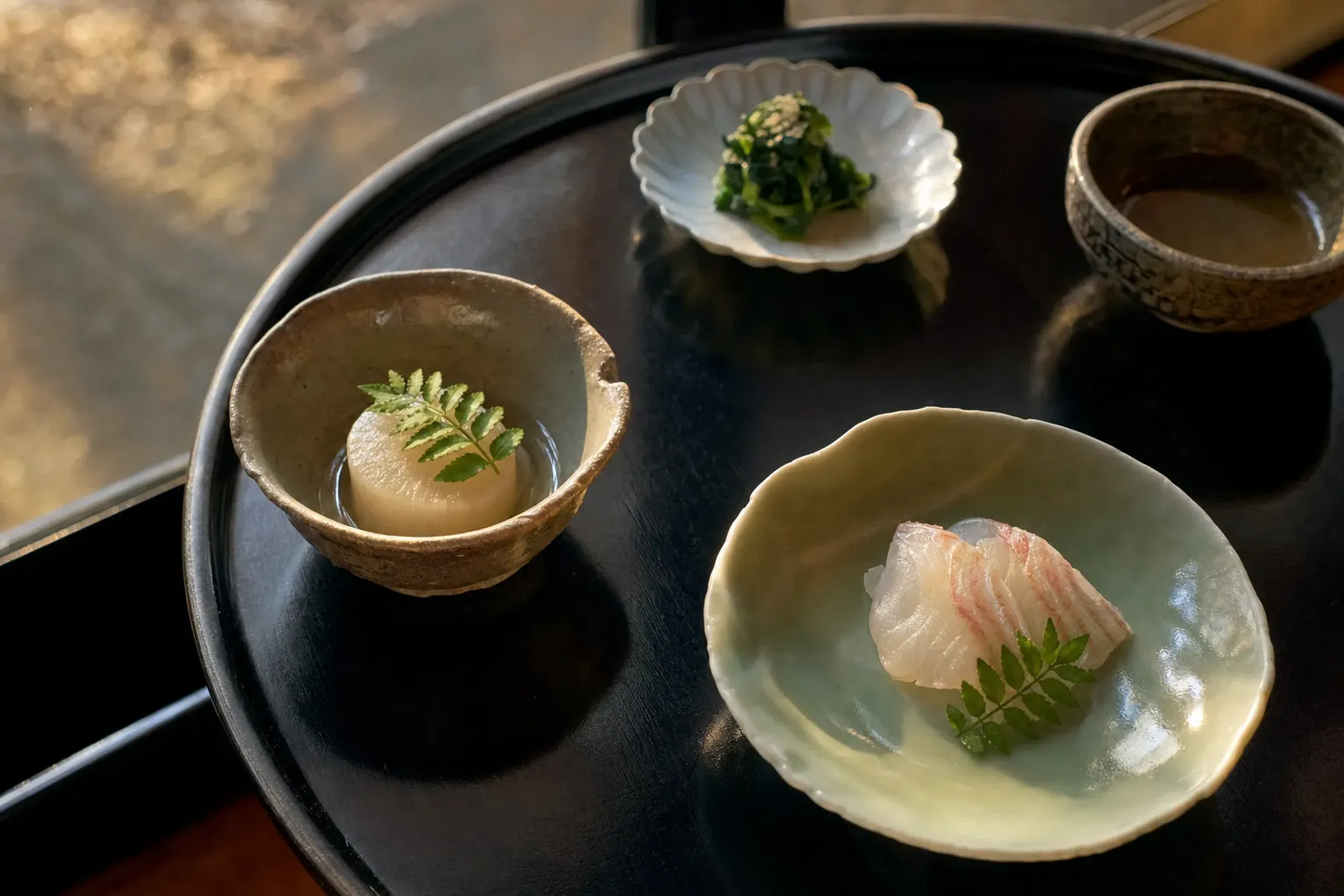 A multi-course kaiseki dinner arrangement at Gora Kadan featuring seasonal Hakone and Odawara produce plated on lacquered trays and ceramic dishes
