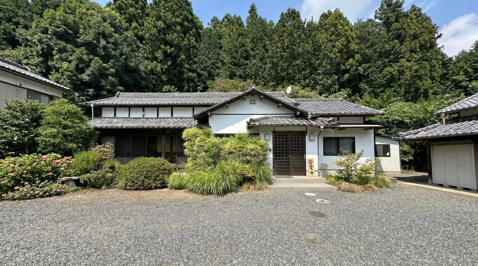 The exterior of Soba-dokoro Goshonoiri, a traditional Japanese kominka nestled in the lush mountains of Tochigi.