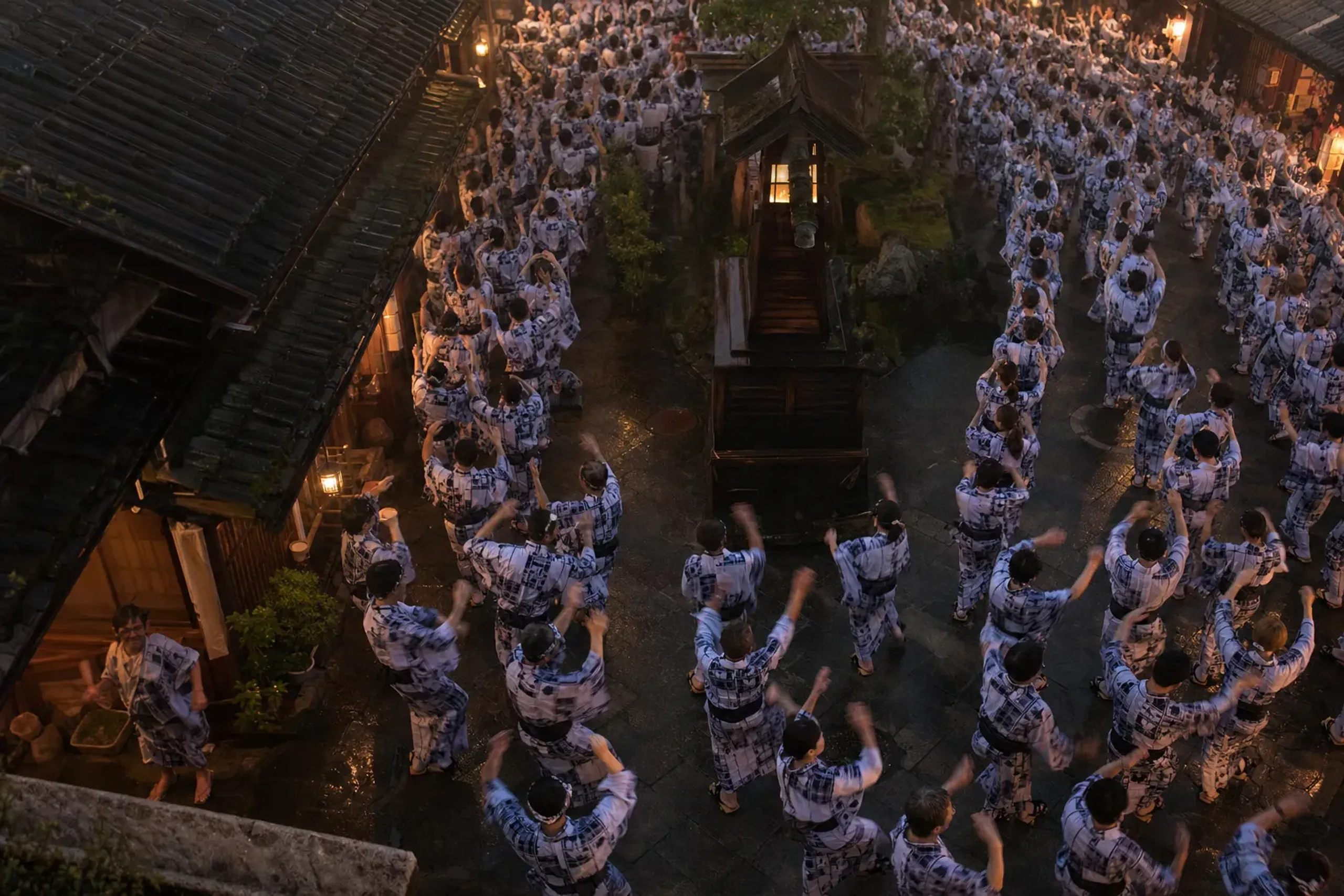 A dense circle of yukata-clad dancers filling a Gujō Hachiman street at dawn during the all-night Tetsuya Odori
