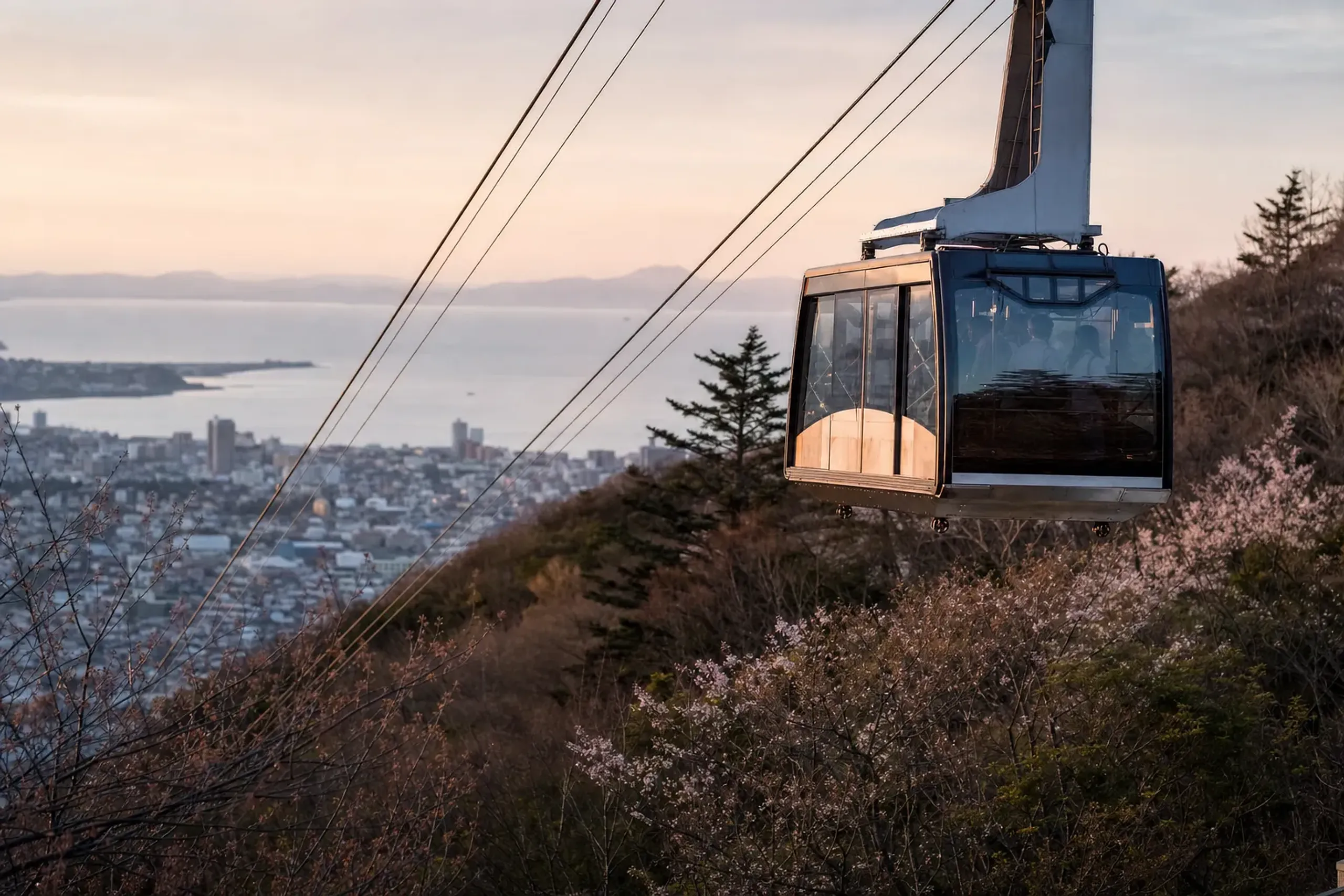 the Mount Hakodate ropeway cabin ascending the wooded slope above the city