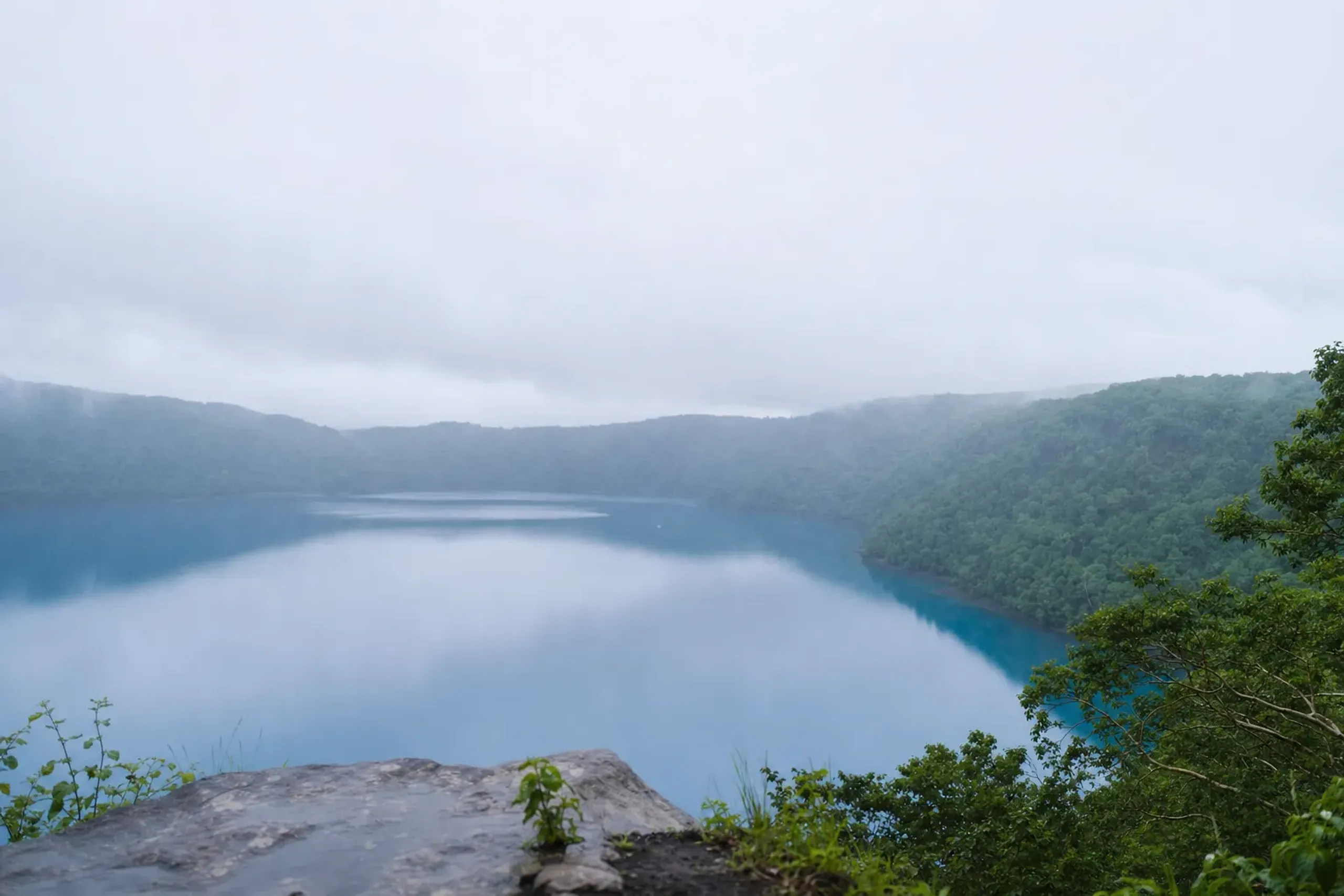Clear blue volcanic crater lake in an eastern Hokkaido national park