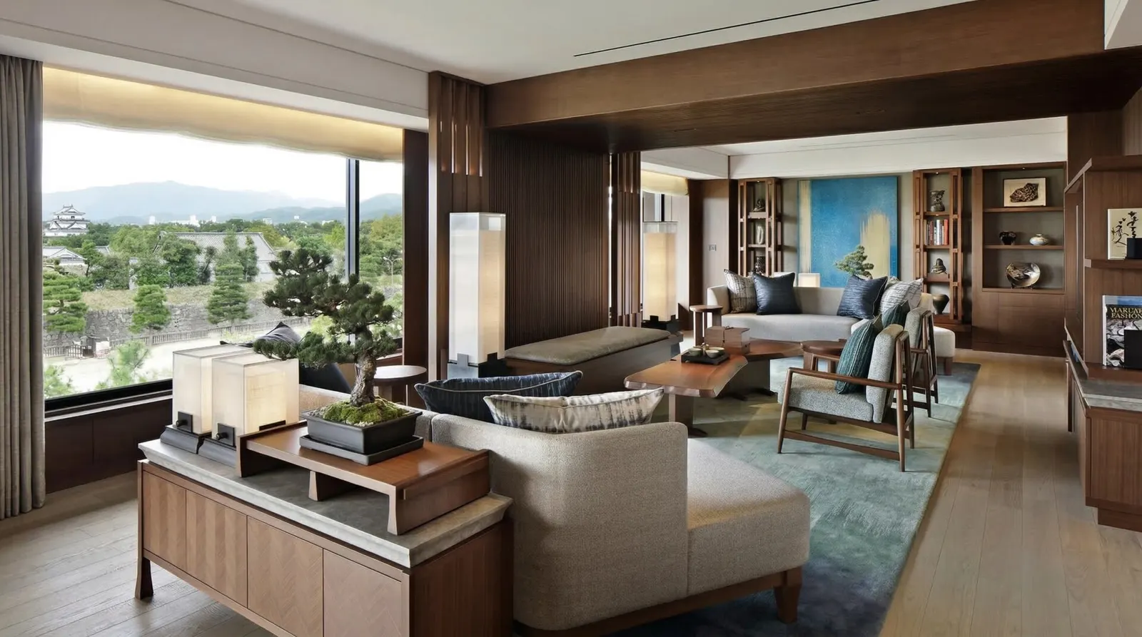 A spacious and elegantly furnished living room in the Presidential Suite with large windows overlooking greenery.