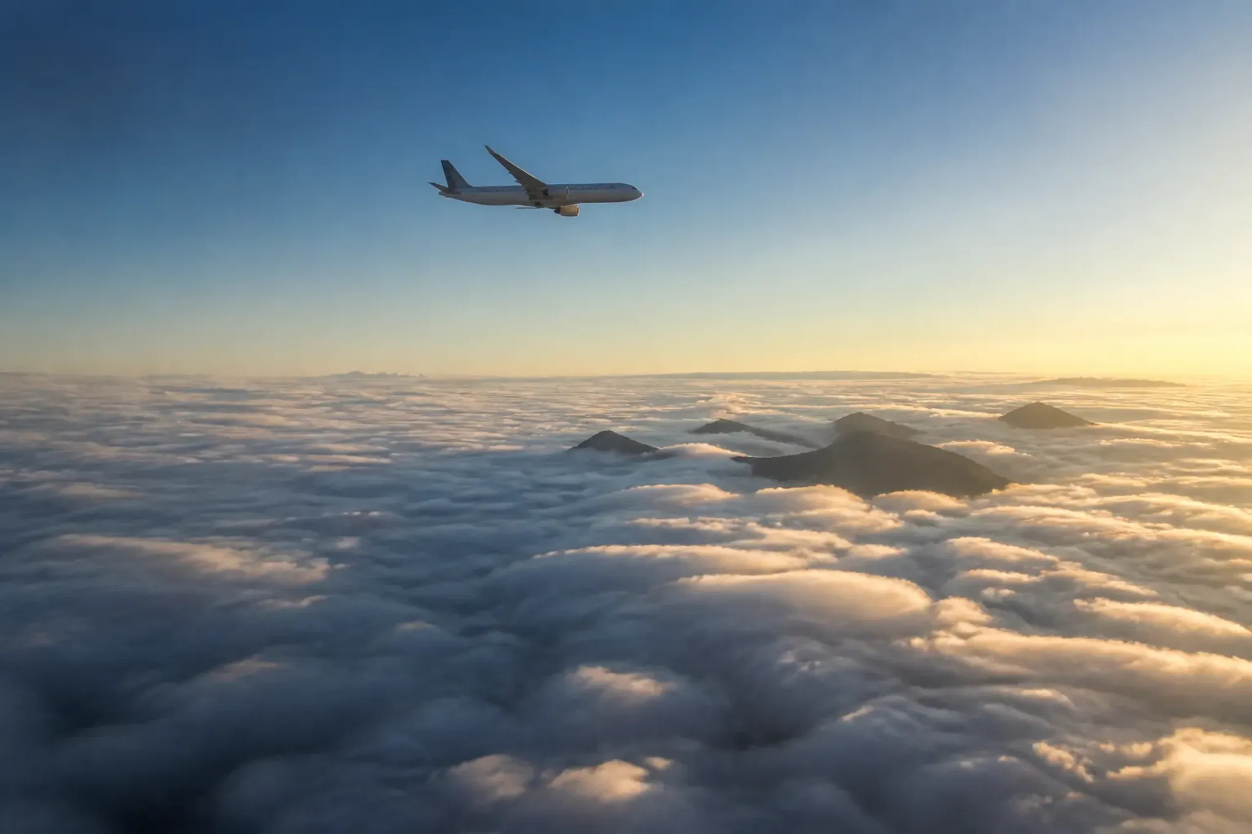 A domestic Japanese airliner cruising above the cloud layer over the mountainous Japanese archipelago, connecting distant regions like Hokkaido and Okinawa that reshape the travel map