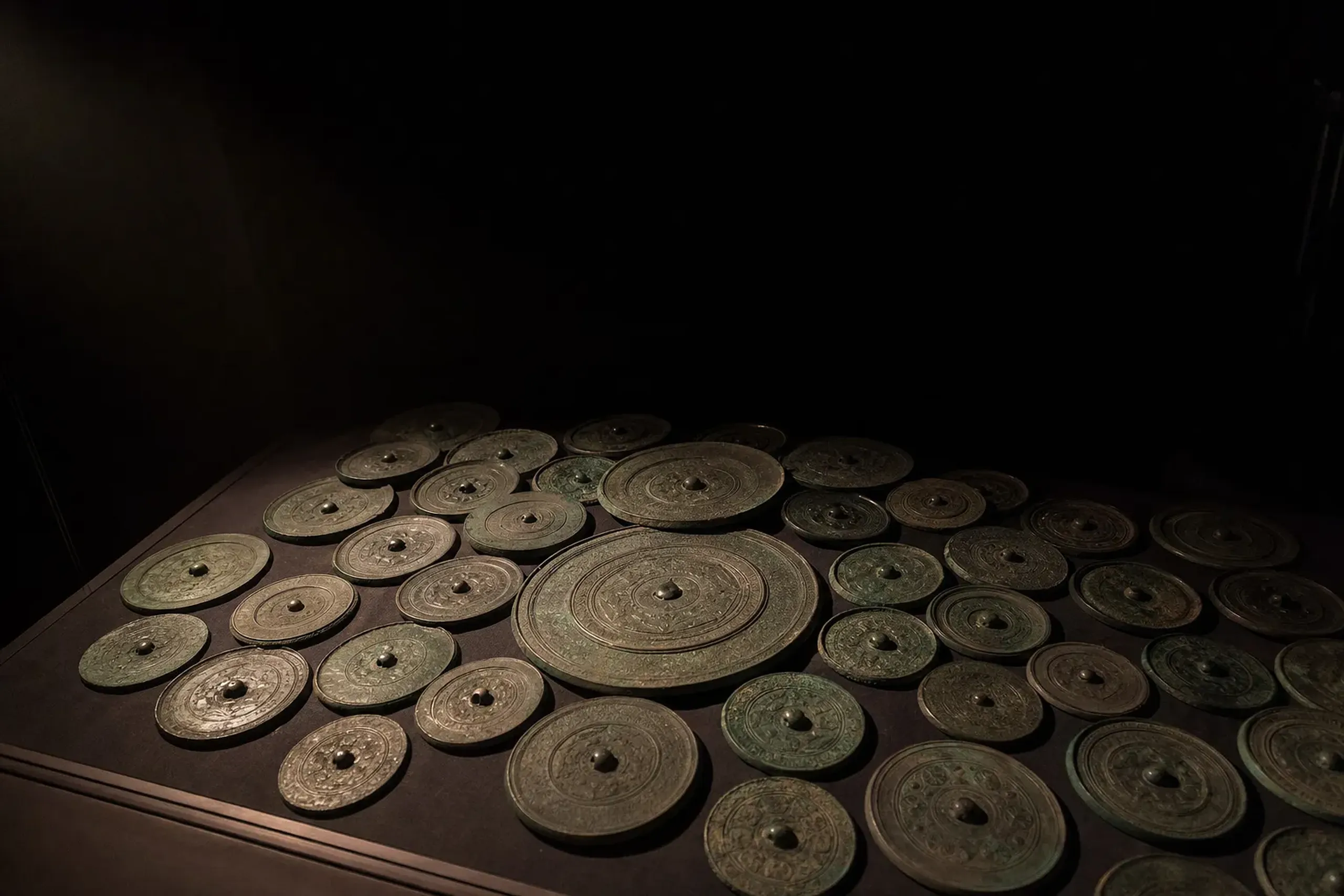 The cluster of forty bronze Yayoi-period mirrors from the Hirabaru tomb arranged together, National Treasures of Itoshima