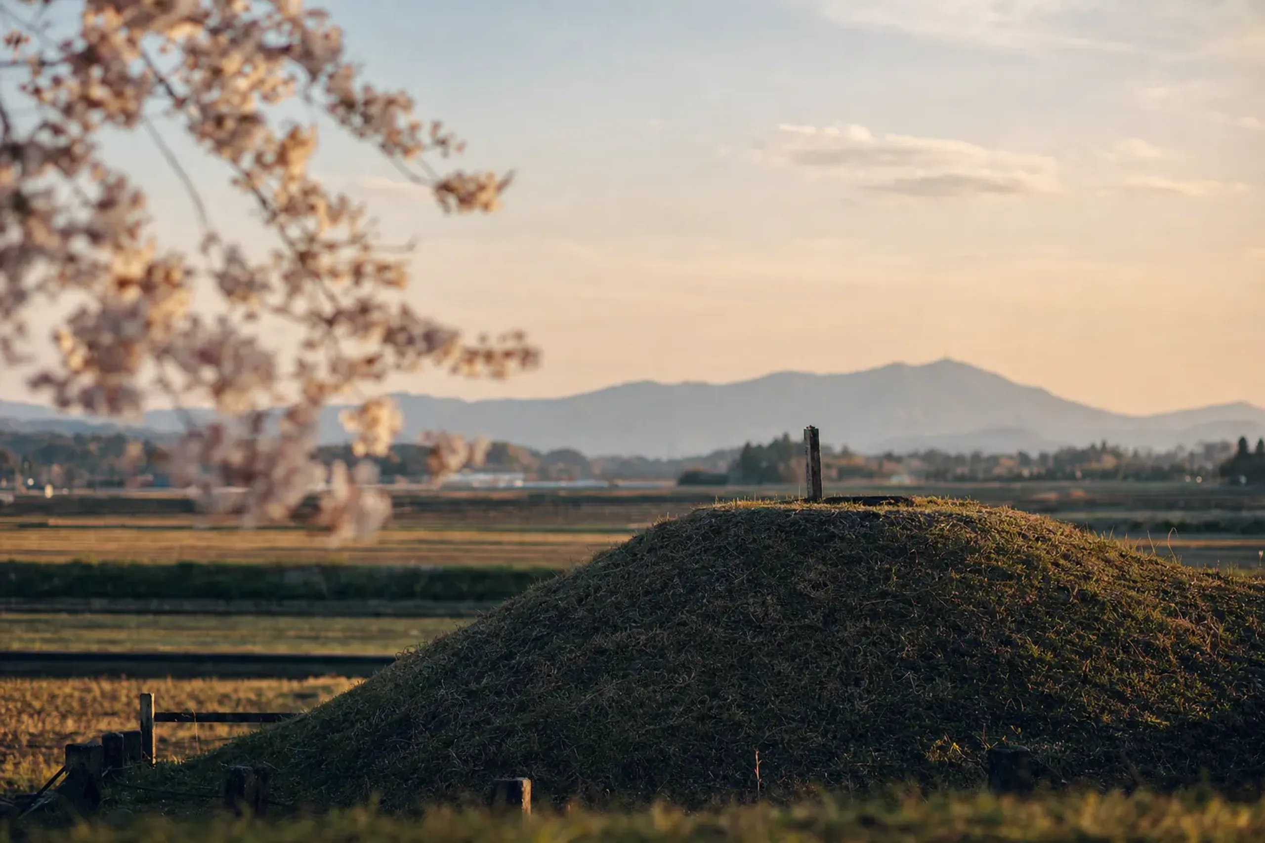 The earthen burial mound of the Hirabaru tomb in Itoshima under late afternoon light