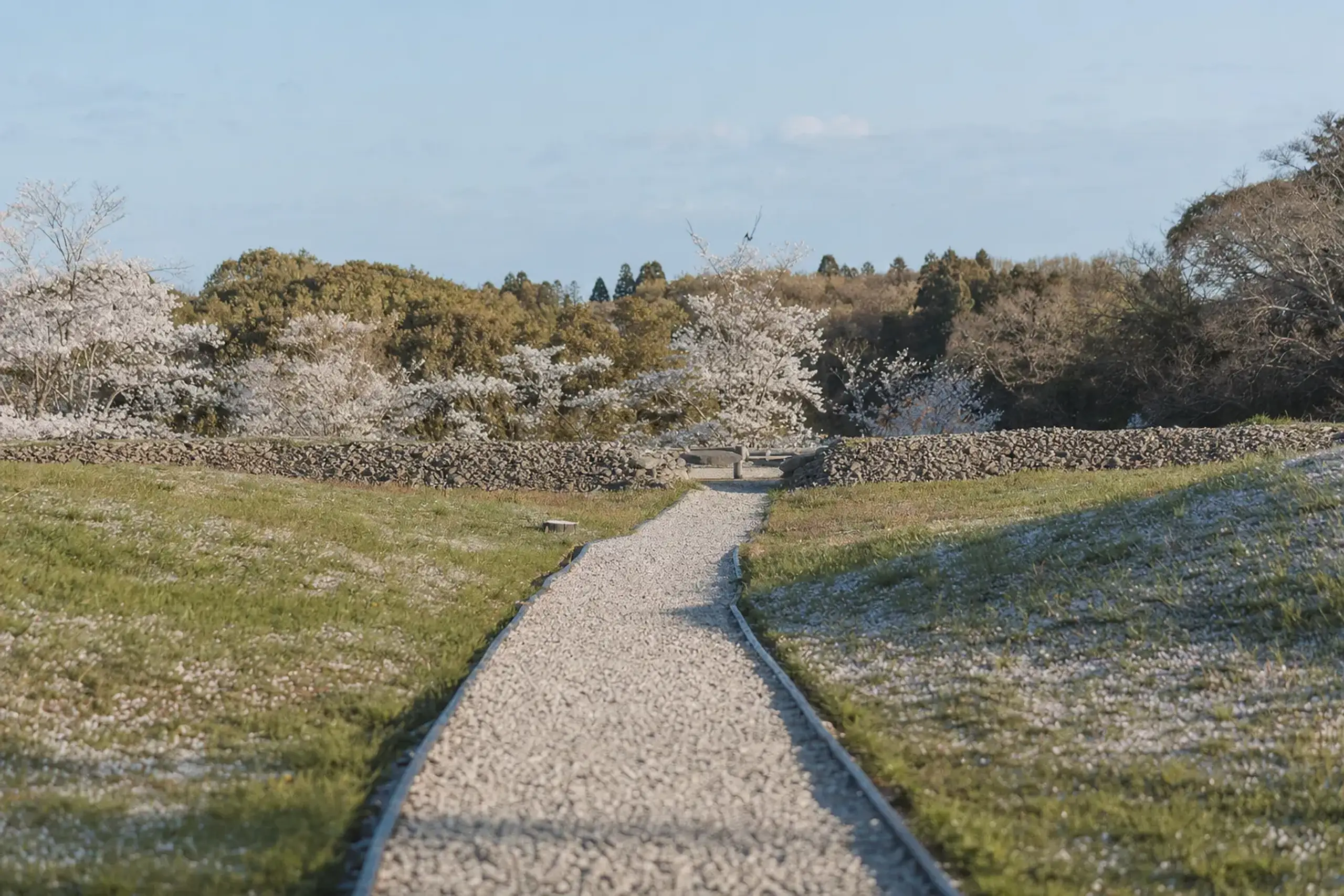A gravel walking path leading through the Hirabaru royal tomb site in Itoshima