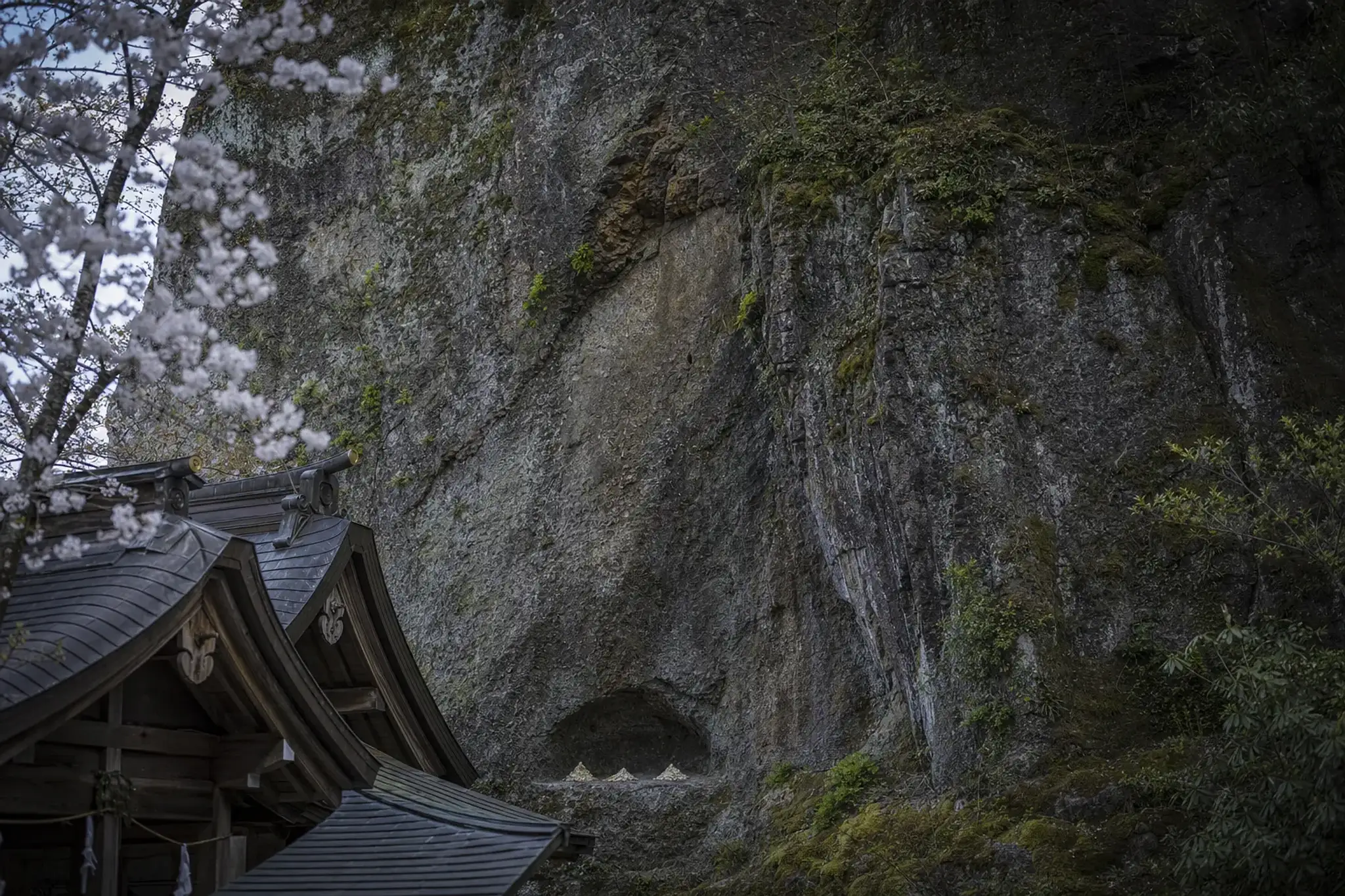 The exposed rock face at the base of Mount Yakumo behind the Soganoyashira sub-shrine at Izumo Taisha, with collected sacred o-suna sand
