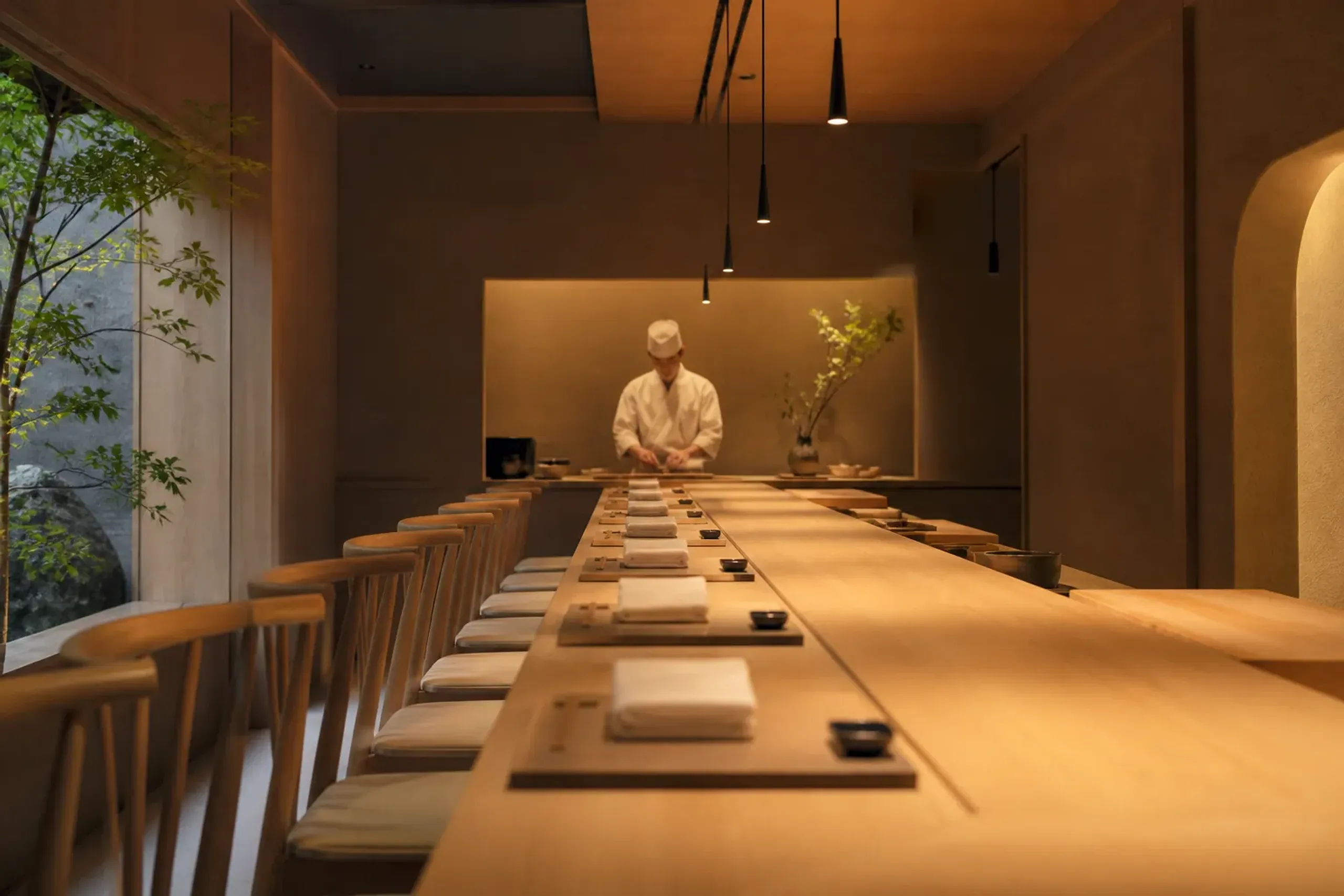 Small Japanese restaurant counter with a limited number of wooden seats and a chef work area