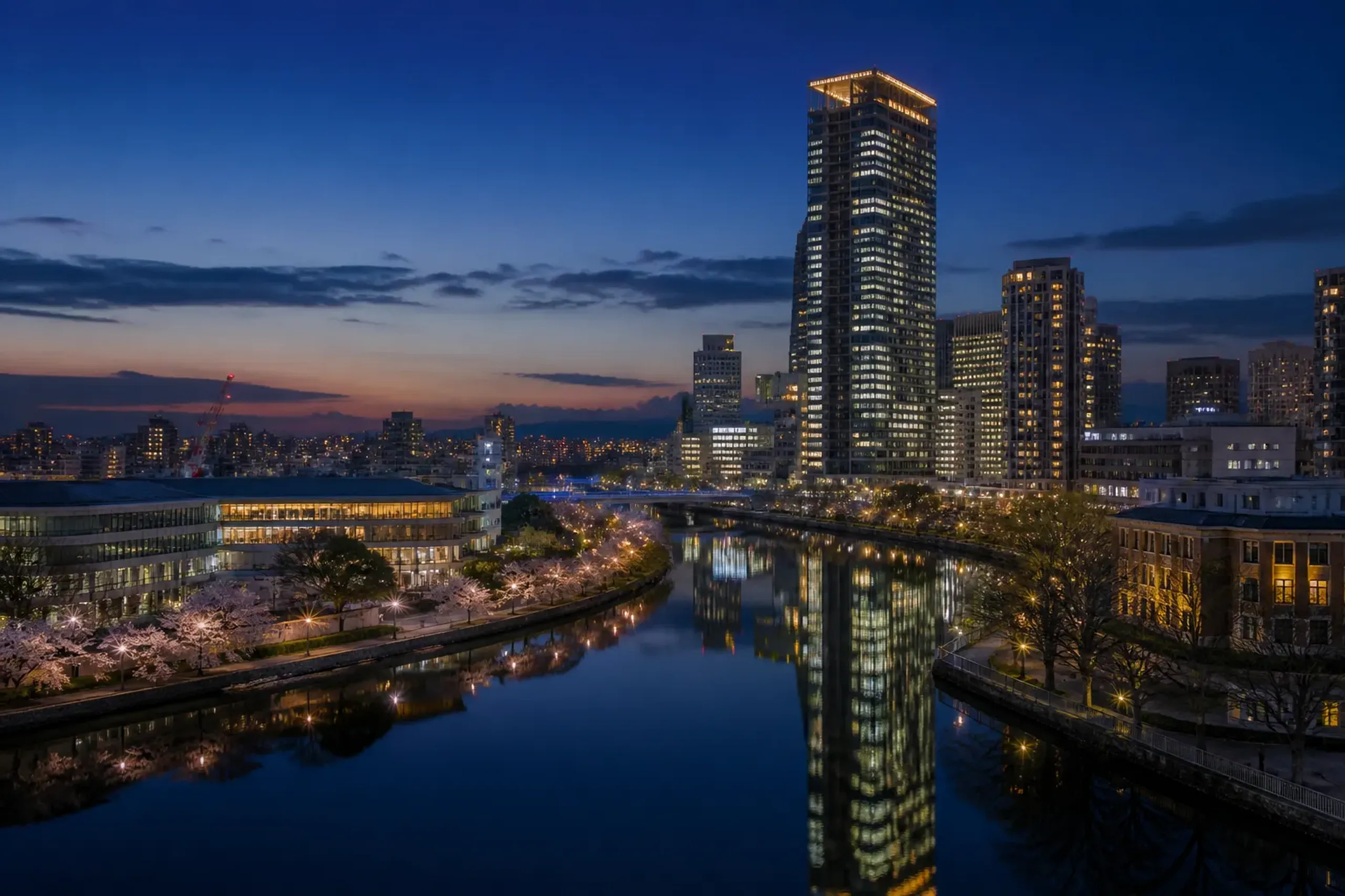 Osaka skyline at night with river reflections and modern towers