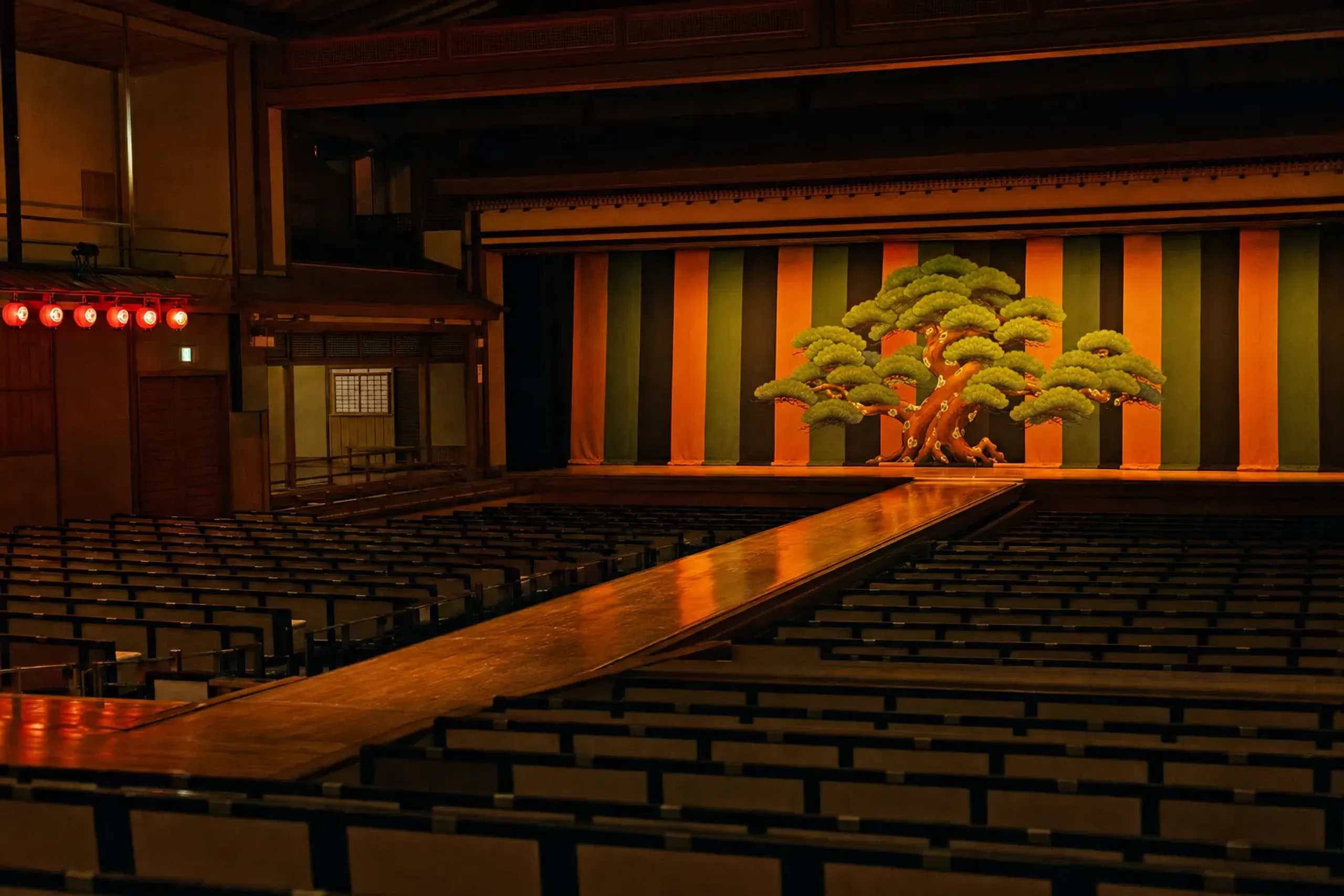 The empty Kabukiza main stage with its hanamichi walkway extending into the auditorium, lit warmly before a summer performance
