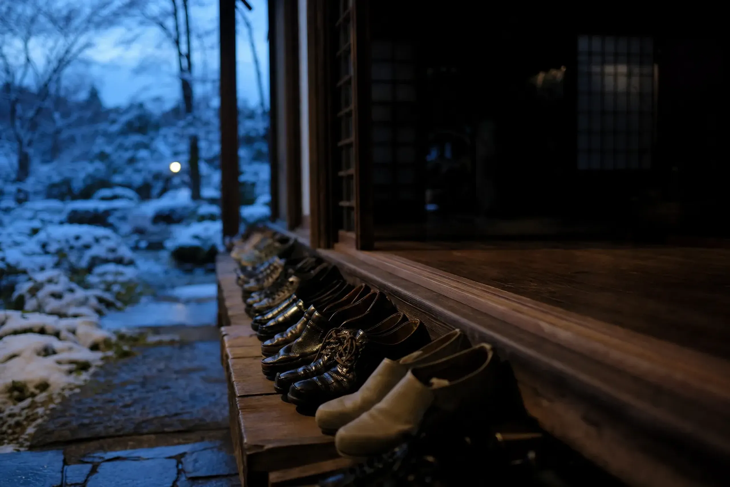 A row of visitors' shoes lined up neatly at the edge of the Engaku-ji hall floor before dawn zazen