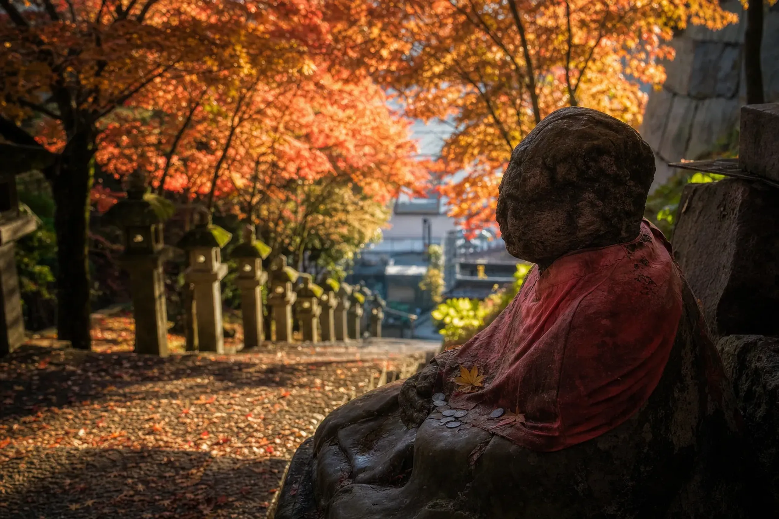 The Obinzuru-sama statue in the courtyard of Renkei-ji Temple surrounded by blooming Somei-Yoshino cherry blossoms