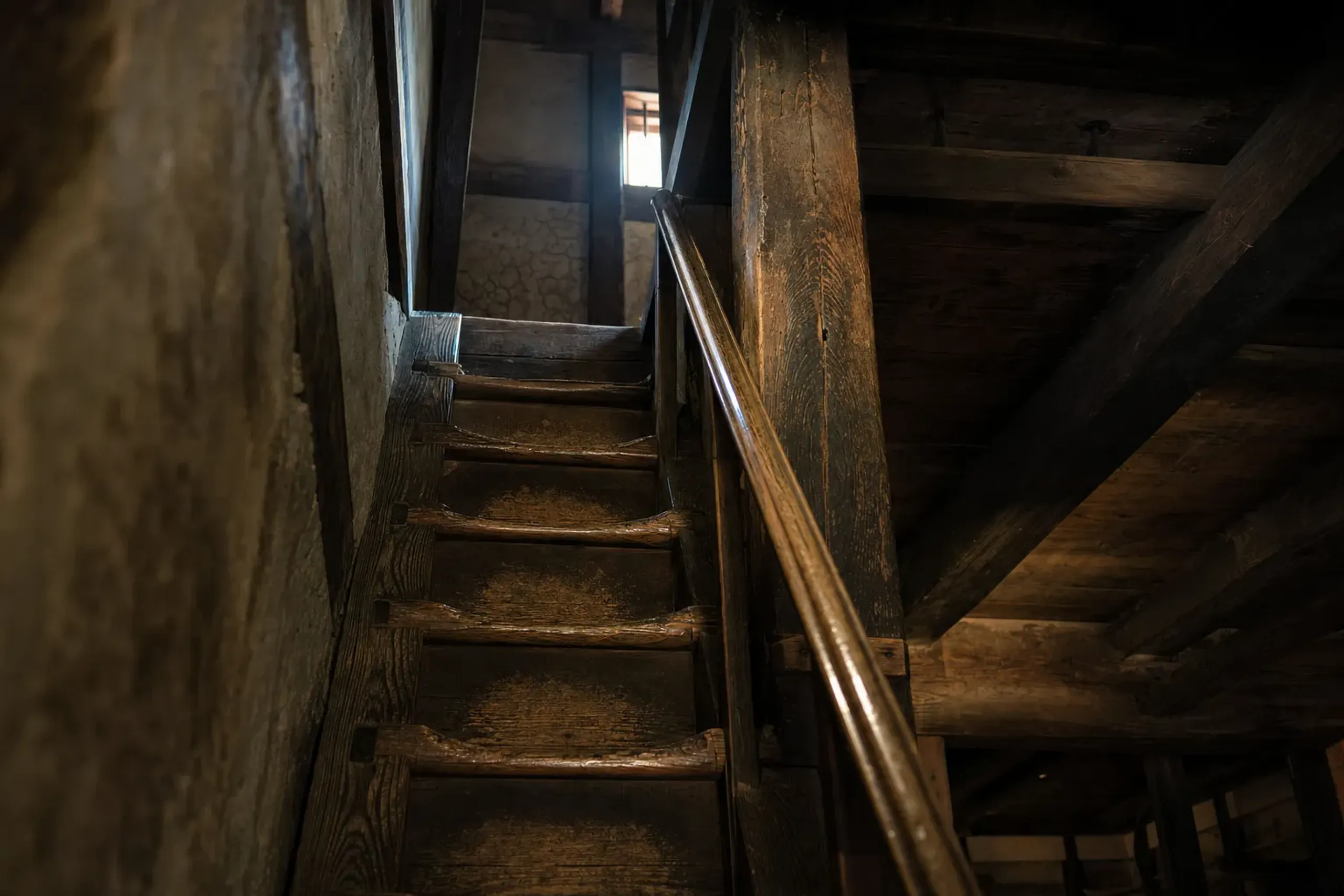 the worn, sheen-polished timber staircase inside Kōchi Castle's original wooden keep, showing exposed joinery of aged dark timber