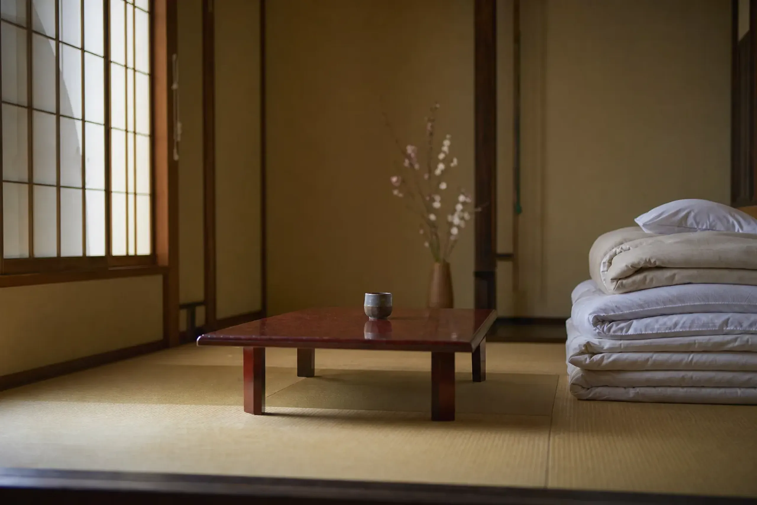 Simple tatami room with futon and shoji screens at a small Japanese inn