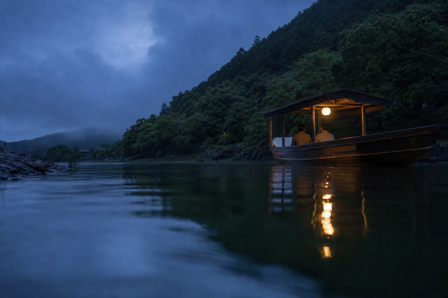 Private wooden charter houseboat with lantern drifting at dusk on the Oi River in Arashiyama