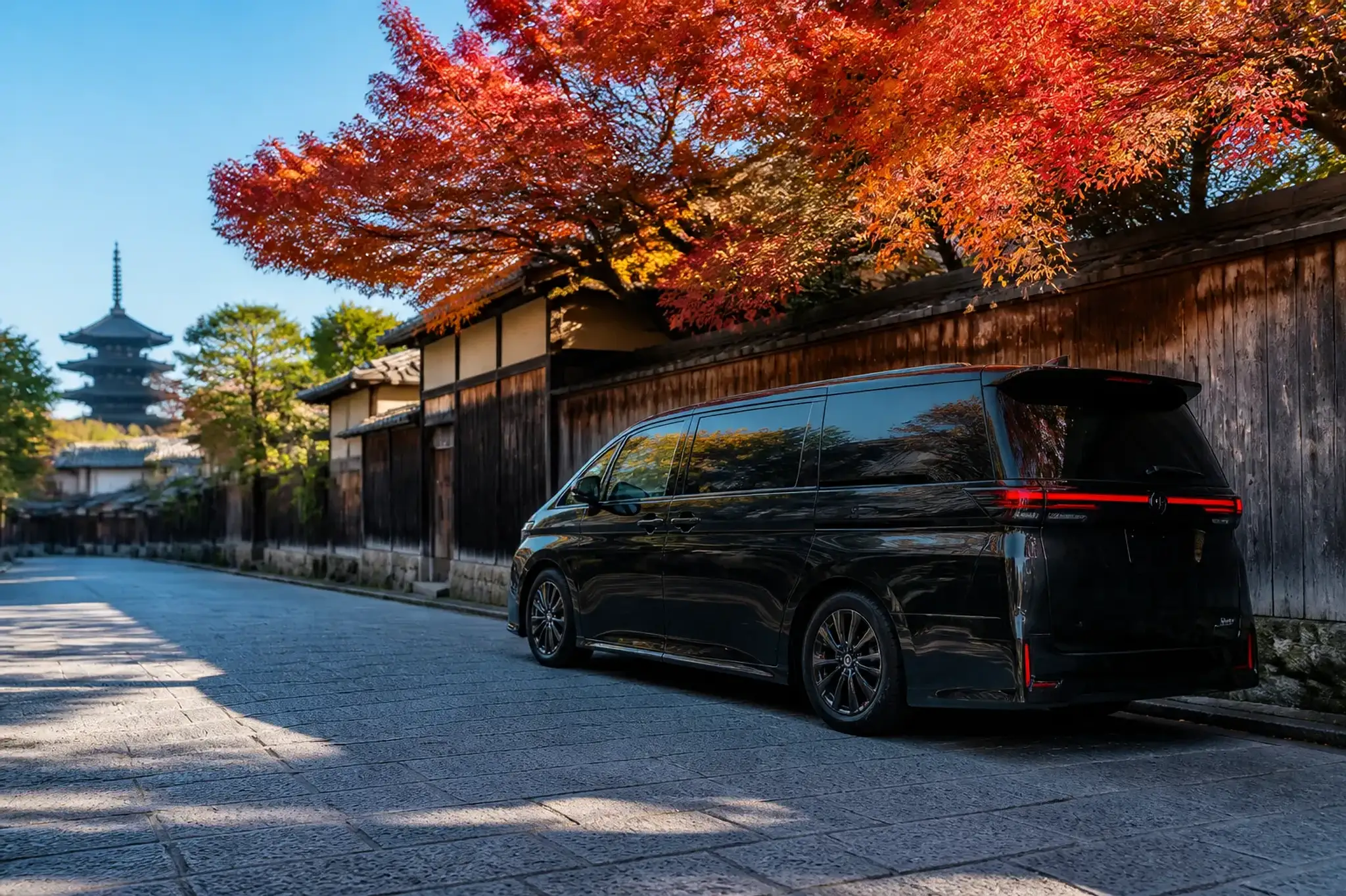 Black luxury minivan with tinted windows on a quiet Kyoto side street, no people